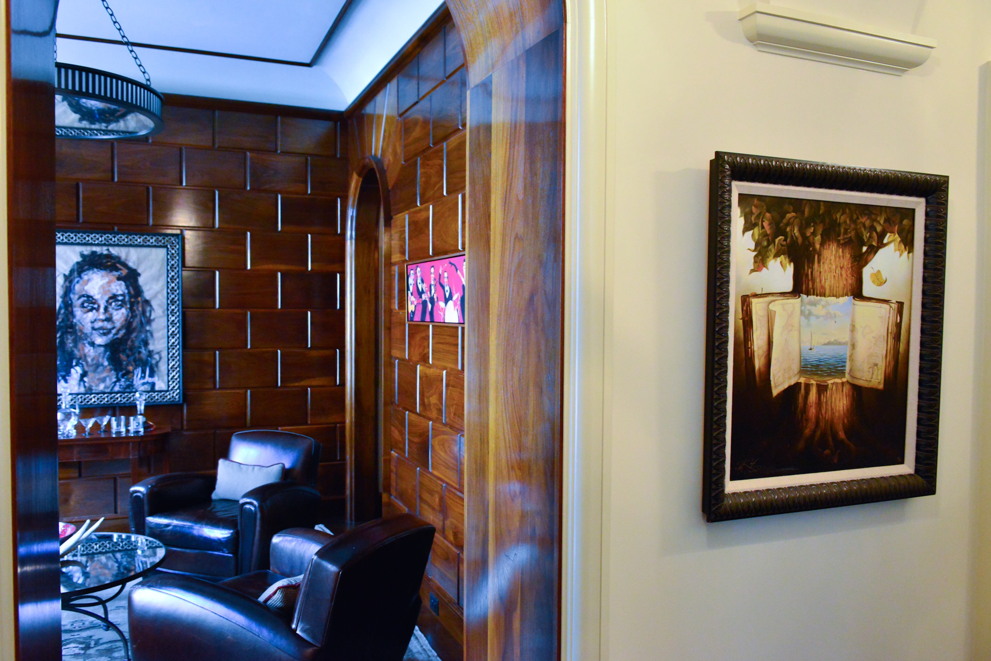 In the foyer, an oil by American realist painter Everett Shinn was purchased at an estate sale by a family member of Edward Labry III, and the piece joins other artwork including a portrait by French artist Atelier Jeremy Kleinberg in the wood-paneled whiskey room.