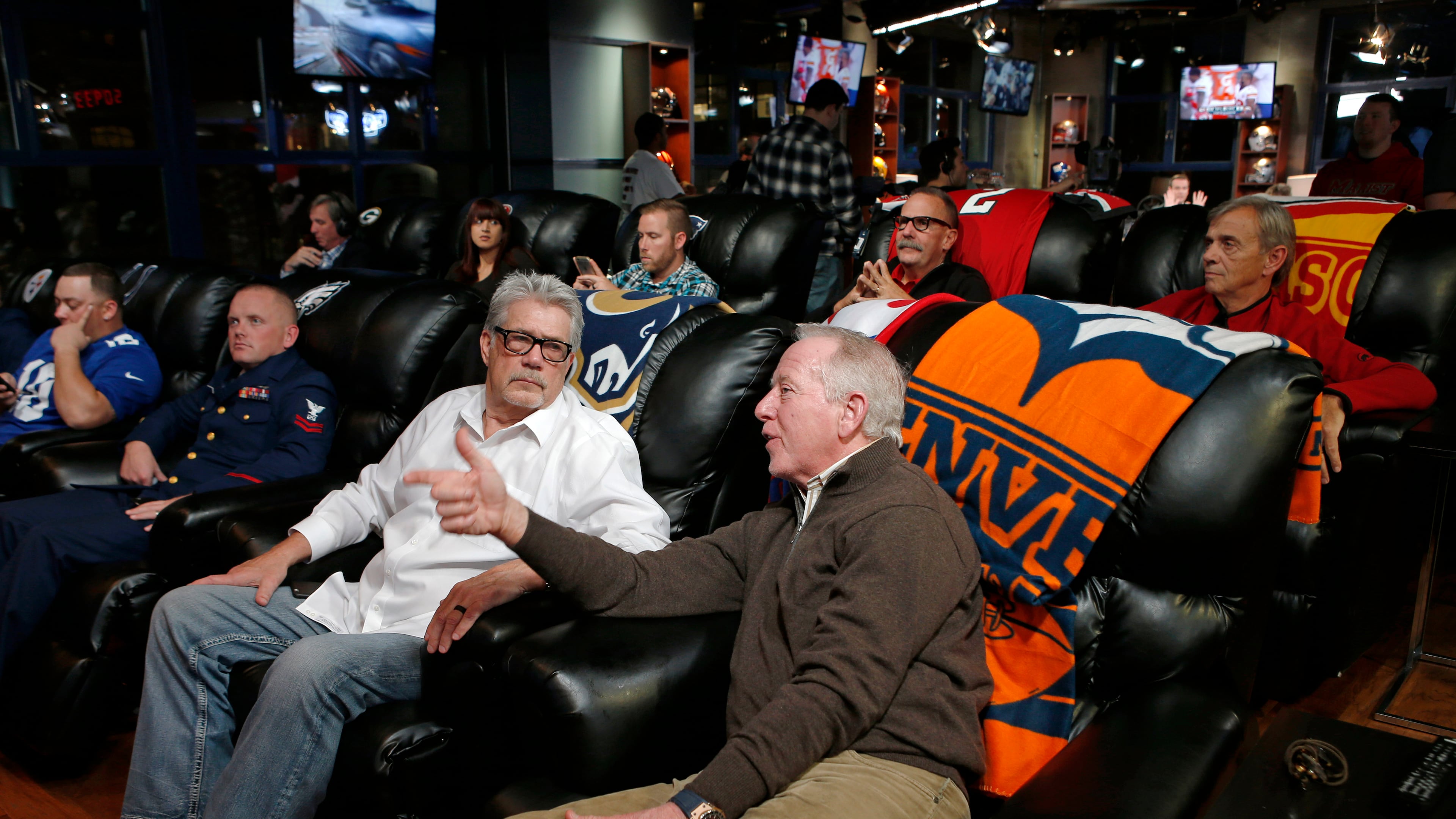 Larry Foles, second from right in front, father of St. Louis Rams quarterback Nick Foles, talks to Archie Manning, father of Denver Broncos quarterback Peyton Manning and New York Giants quarterback Eli Manning, as they watch coverage of their sons playing in NFL football games, Sunday, Nov. 15, 2015, in New York. The pair were joined by Mike Ryan, father of Atlanta Falcons quarterback Matt Ryan, second row, second from right, and Doug Smith, second row, right, father of Kansas City Chiefs quarterback Alex Smith. (AP Photo/Kathy Willens)