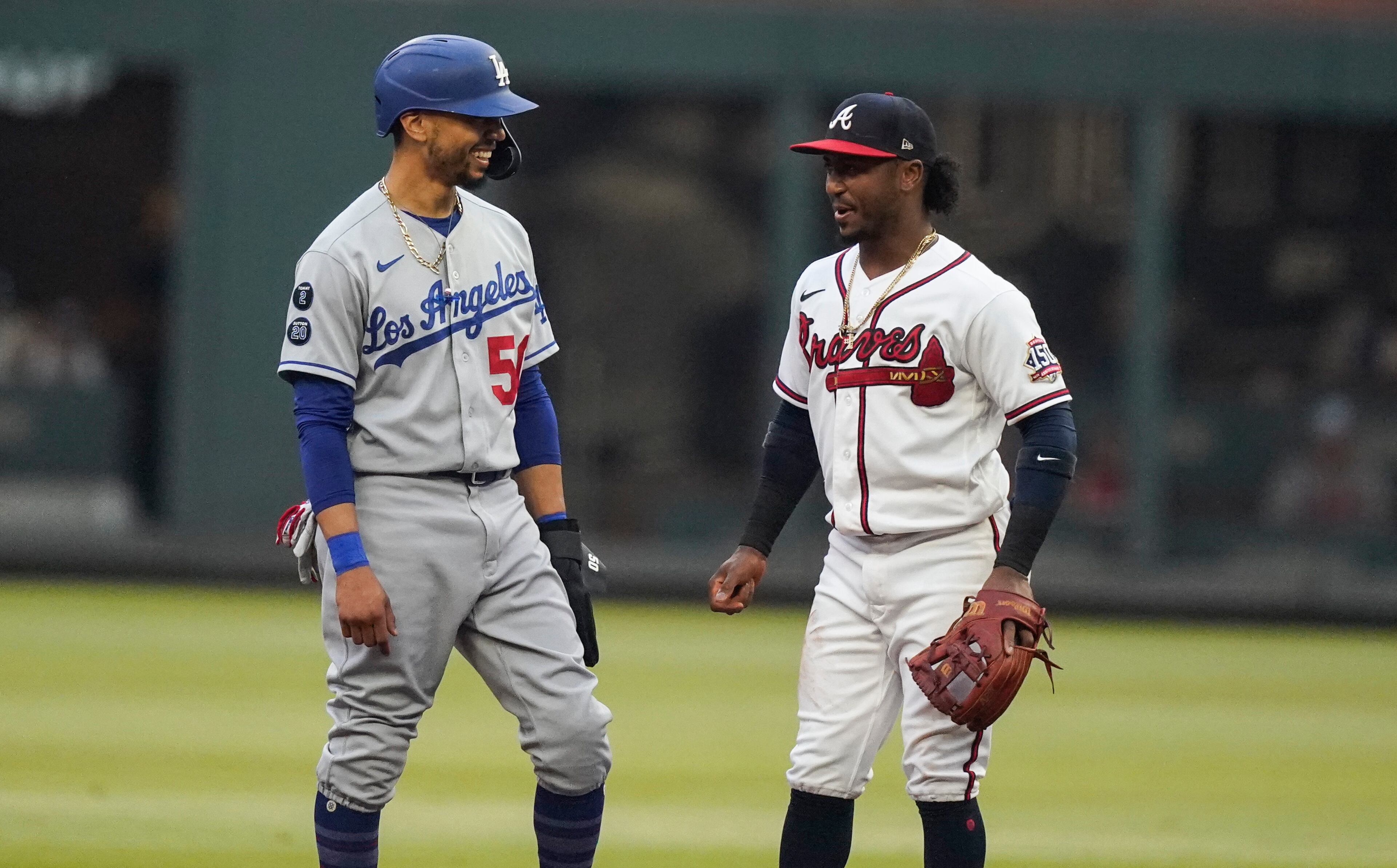 Los Angeles Dodgers' Mookie Betts, left, laughs with Atlanta Braves second baseman Ozzie Albies, right, in the first inning of a baseball game Saturday, June 5, 2021, in Atlanta. (AP Photo/Brynn Anderson)