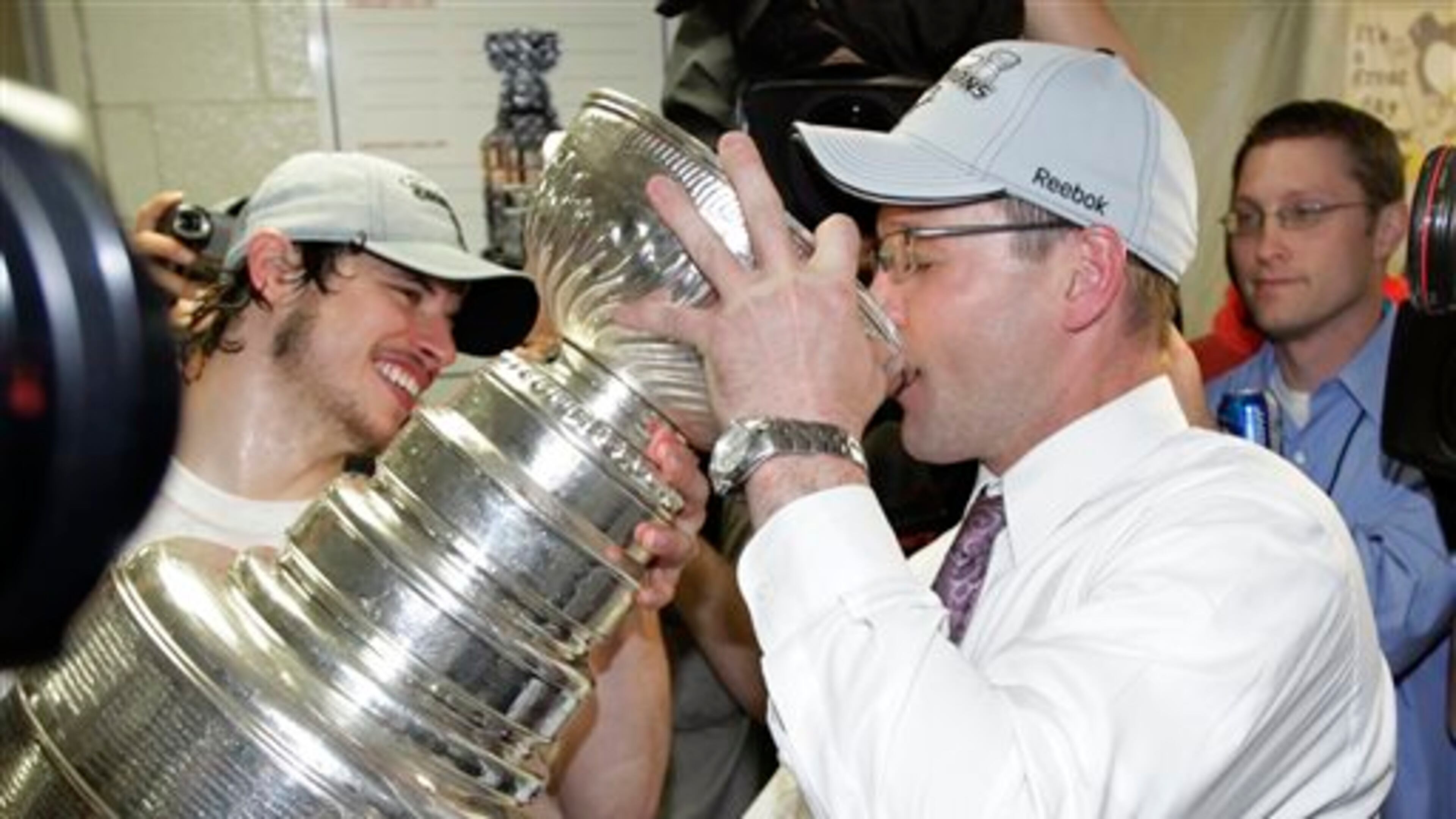 FILE - In this June 12, 2009, file photo, Pittsburgh Penguins' captain Sidney Crosby, left, helps Pittsburgh Penguins head coach Dan Bylsma drink champagne from the Stanley Cup after the Penguins beat the Detroit Red Wings 2-1 to win Game 7 of the NHL hockey Stanley Cup finals, in Detroit. Michael Schuckers, a statistics professor at St. Lawrence University in northern New York, said it�s also difficult to gauge the impact of a coach, unless there�s something like a team that�s relatively static and the only change made is the coach. �When the Penguins won the Stanley Cup, you can look at how the Penguins were under (current Montreal Canadiens coach Michel) Thierren (27-25-5) and under (Dan) Bylsma (18-3-4),� Schuckers said. �It's a clear break in terms of the team playing much better under Bylsma.� (AP Photo/Paul Sancya, File)