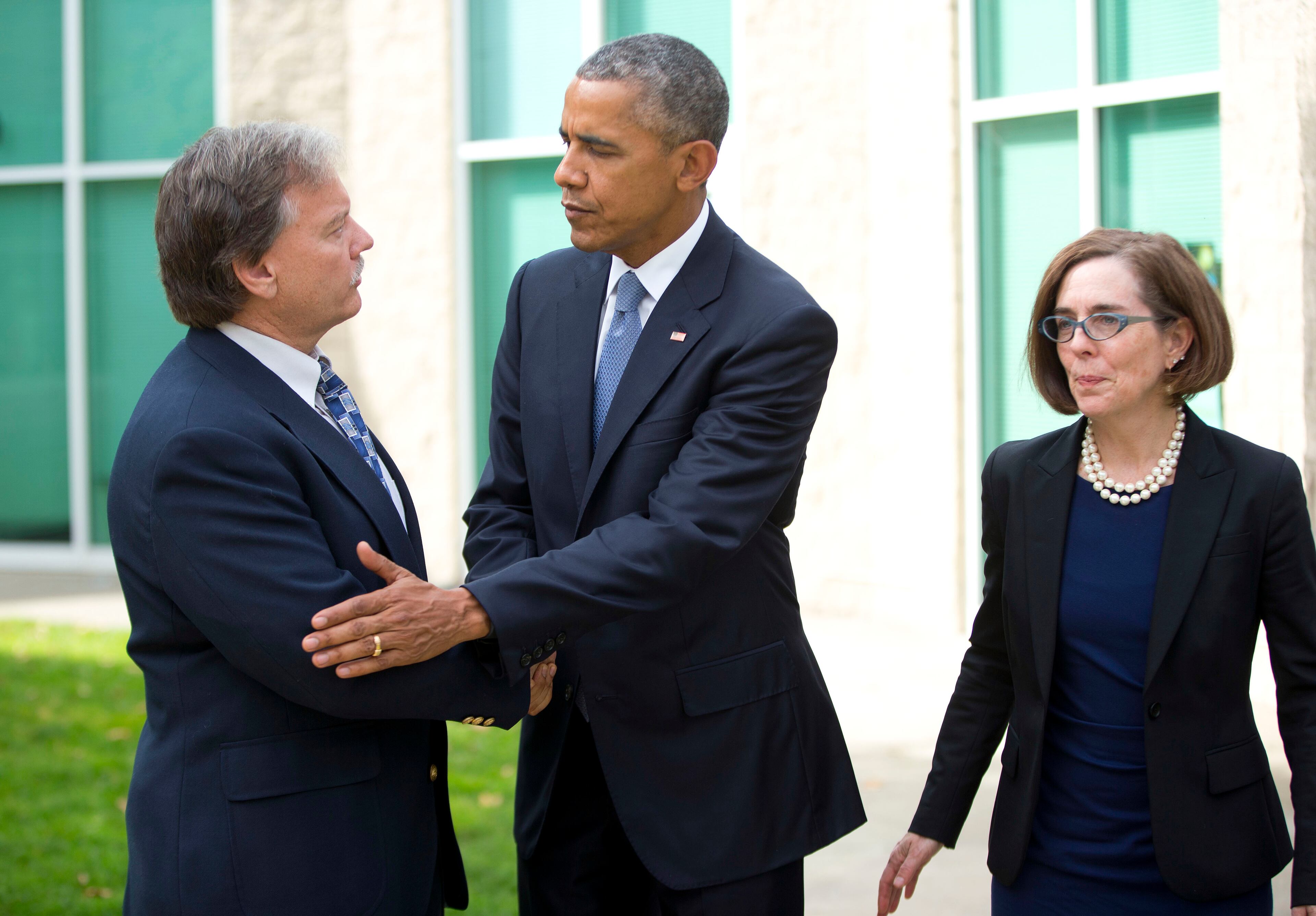 President Barack Obama, center, shakes hands with Roseburg Mayor Larry Rich, left, as Oregon Gov. Kate Brown, right, looks on following their meeting with families of the victims of the Oct. 1, shooting at Umpqua Community College, Friday, Oct. 9, 2015 in Roseburg, Ore. (AP Photo/Pablo Martinez Monsivais)