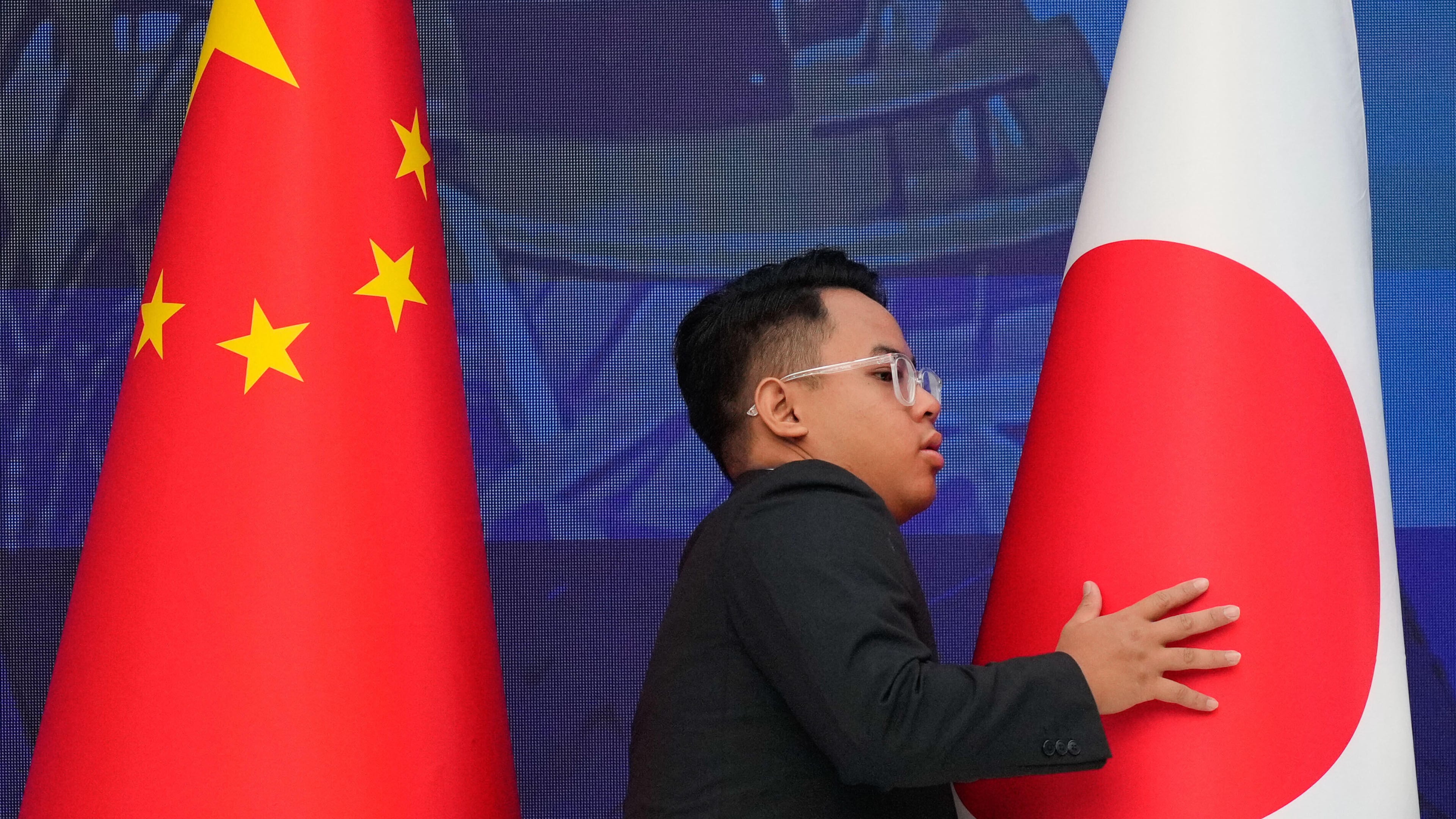 FILE - A staff organise flags from China, left, and Japan before the start of the 28th ASEAN Plus Three Summit in Kuala Lumpur, Malaysia, on Oct. 27, 2025. (AP Photo/Vincent Thian, Pool, File)