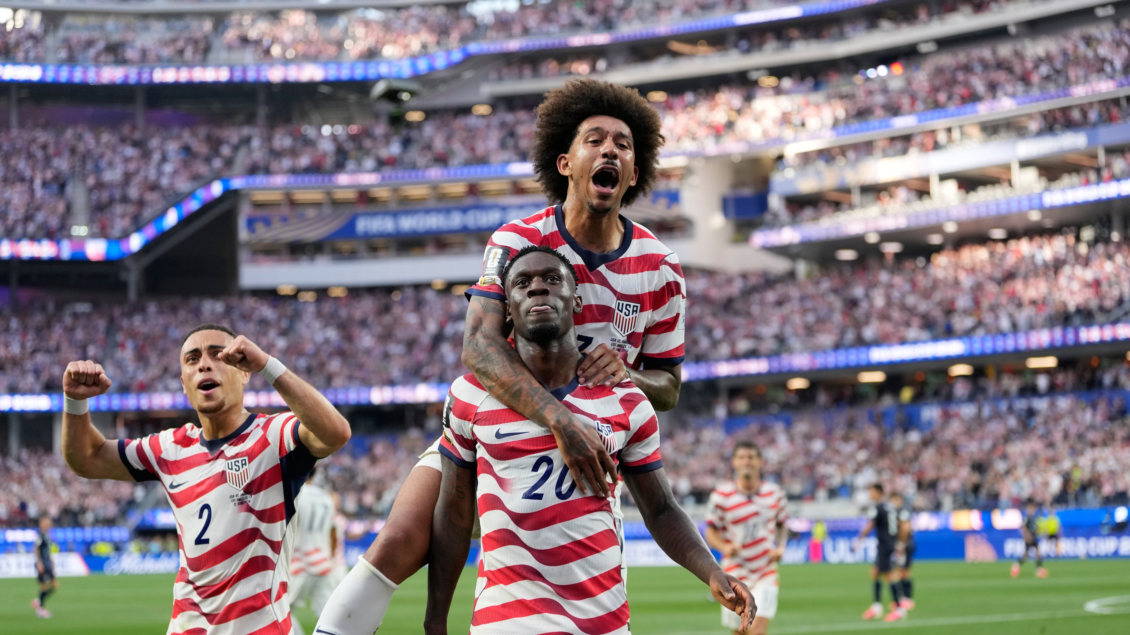United States' Folarin Balogun (20) celebrates scoring his side's third goal against Paraguay with teamates during the World Cup Group D soccer match in Inglewood, Calif., near Los Angeles, Friday, June 12, 2026. (AP Photo/Andre Penner)