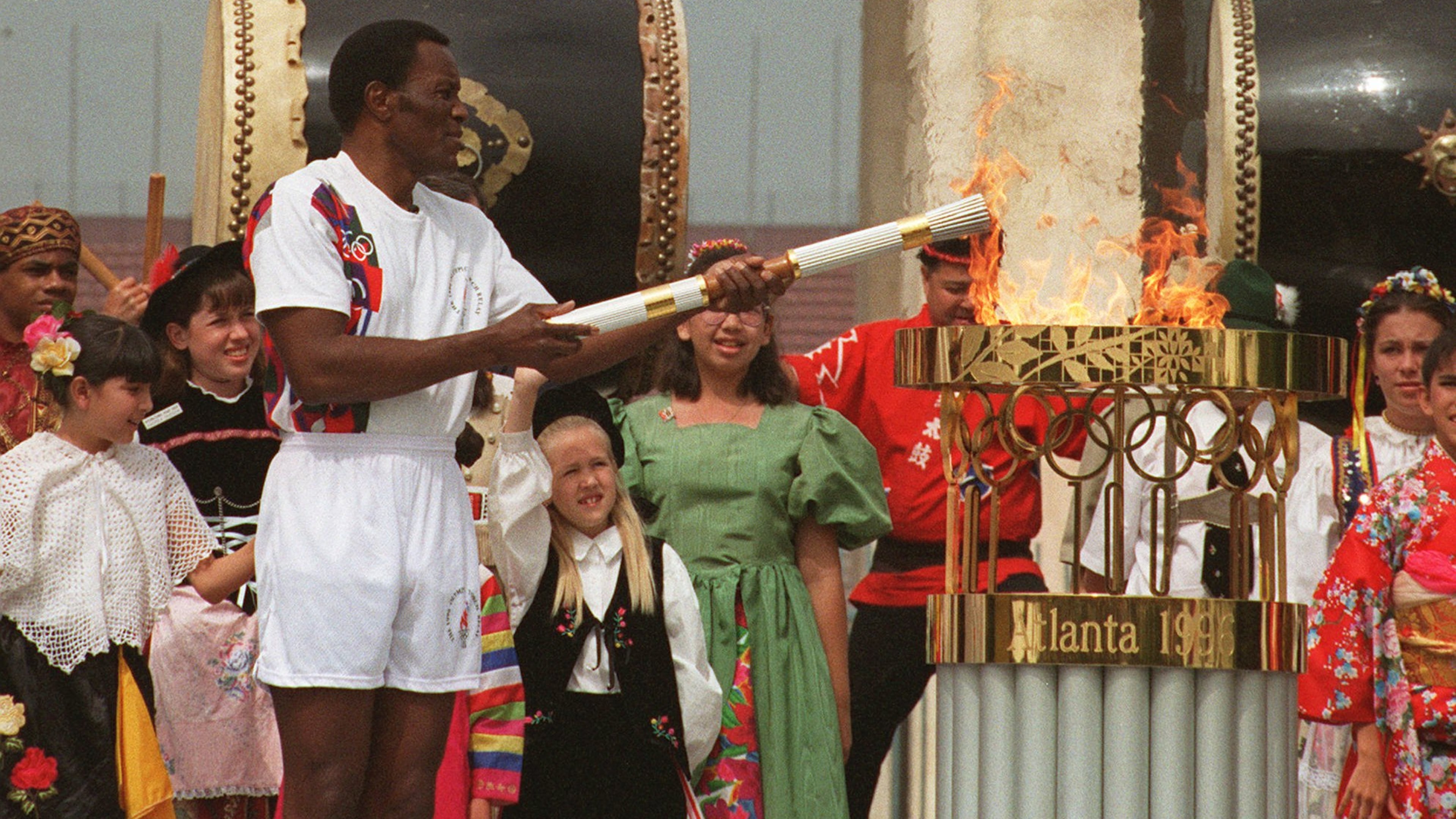 In a nod to history, Olympic decathlon champion Rafer Johnson, the last person to carry the torch on its international journey to the 1984 Summer Olympics, lights the torch from the Olympic flame after its arrival at the Los Angeles Memorial Coliseum, Saturday, April 27, 1996. Johnson was the first torchbearer during its 15,000-mile trip to the opening ceremonies in Atlanta. (Reed Saxon/AP)