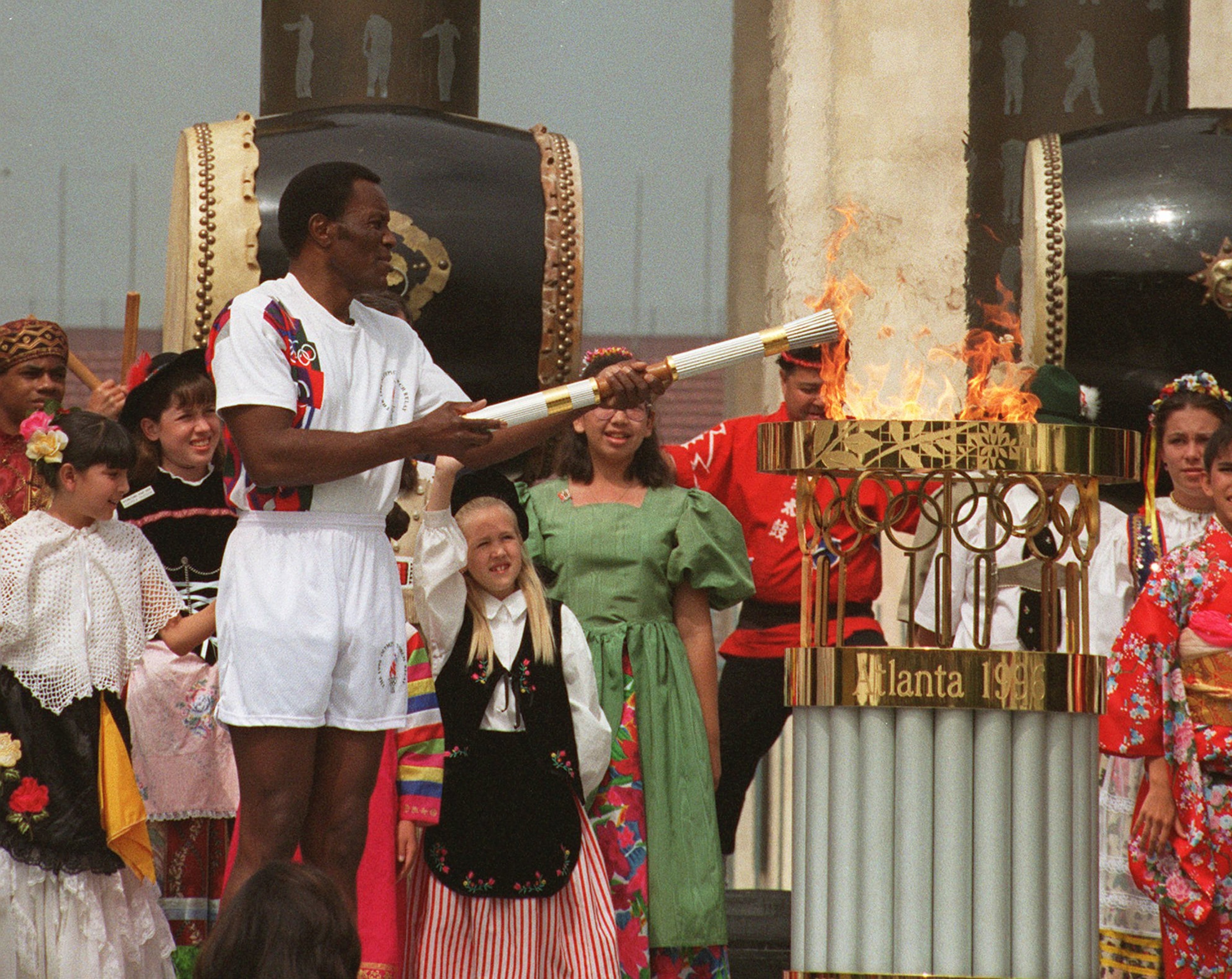 In a nod to history, Olympic decathlon champion Rafer Johnson, the last person to carry the torch on its international journey to the 1984 Summer Olympics, lights the torch from the Olympic flame after its arrival at the Los Angeles Memorial Coliseum, Saturday, April 27, 1996. Johnson was the first torchbearer during its 15,000-mile trip to the opening ceremonies in Atlanta. (Reed Saxon/AP)