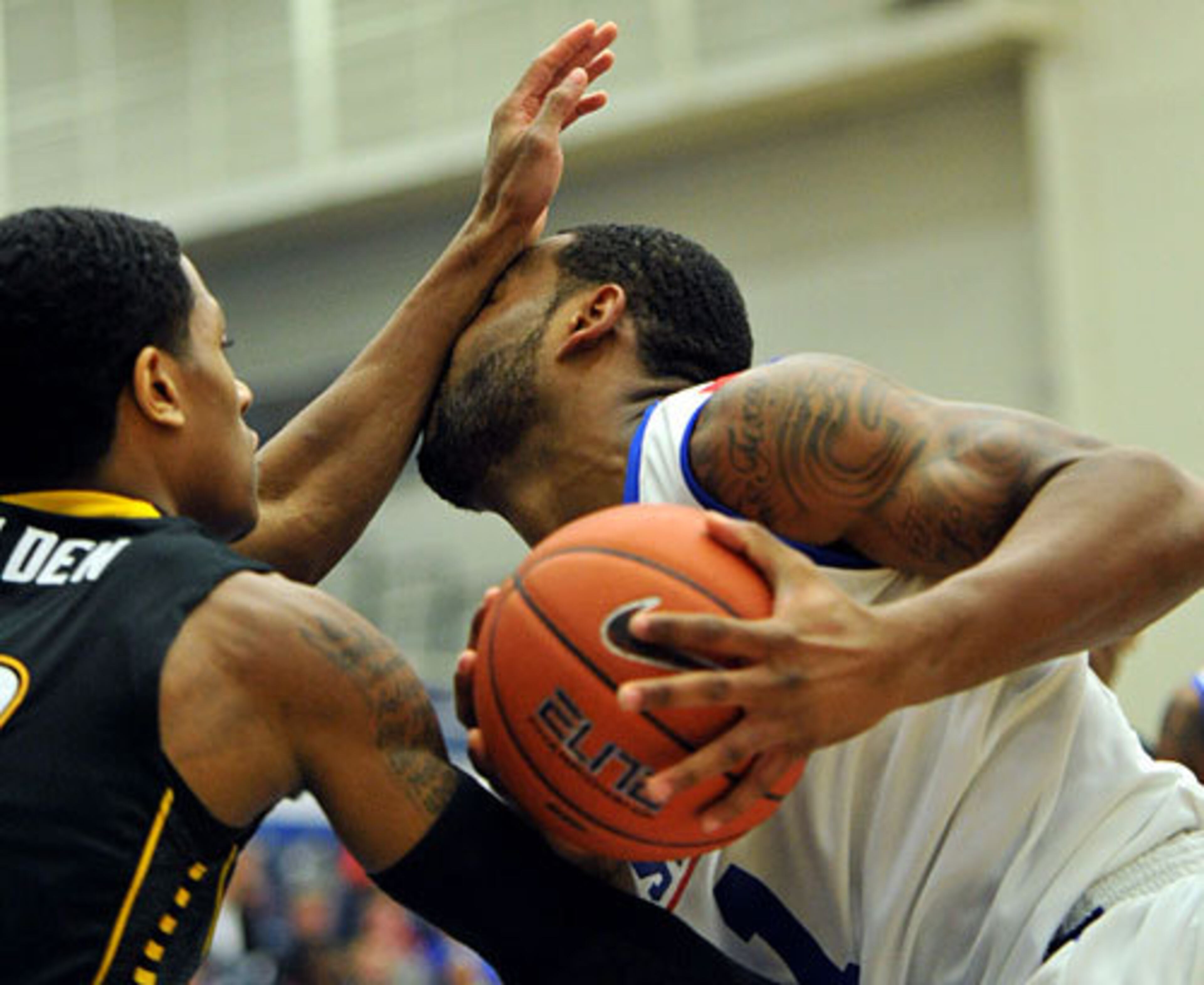 In your face: Georgia State guard Josh Micheaux (right) gets a armful of defense as he tries to dribble past Towson guard Kris Walden.
