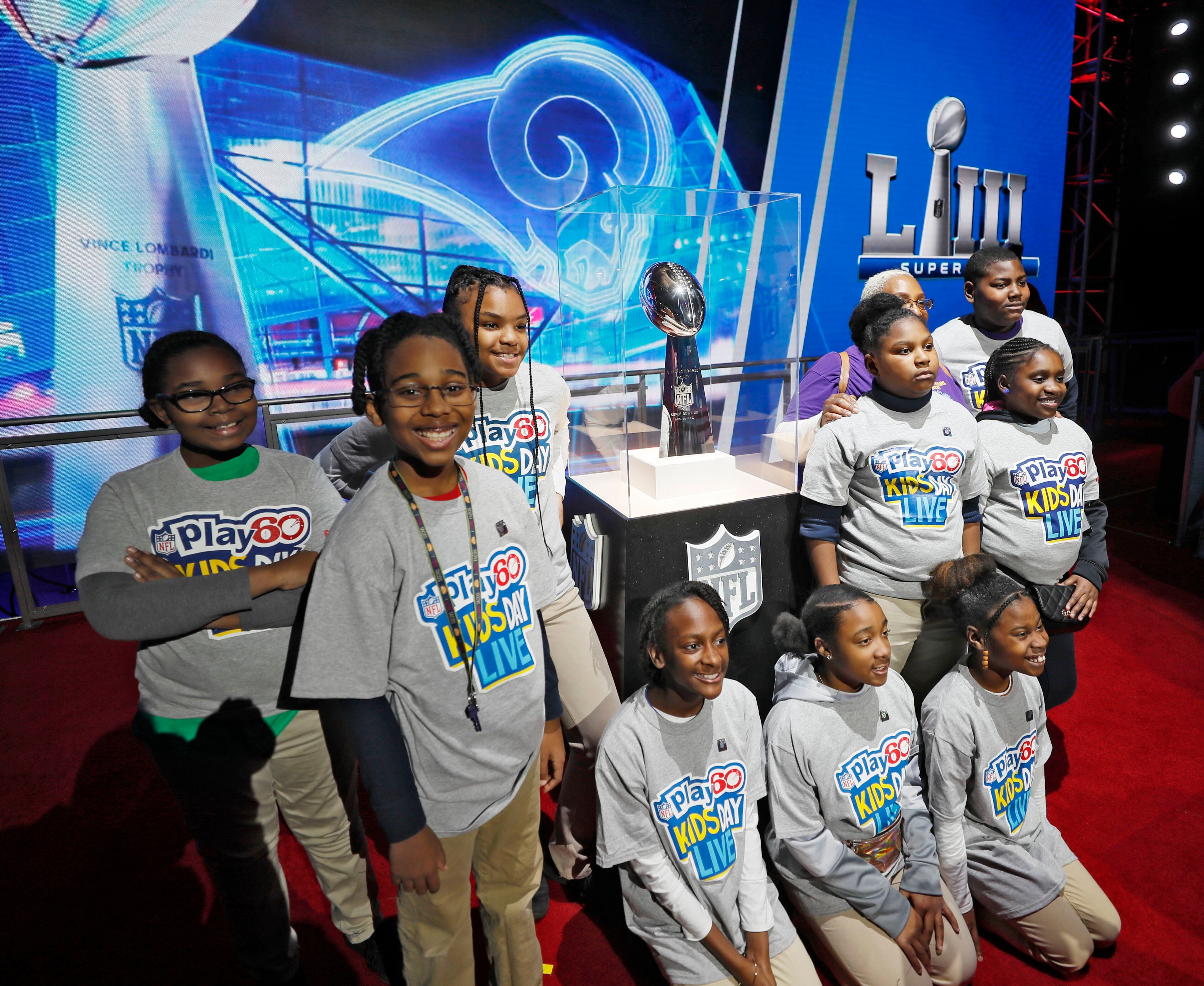 1/30/19 - Atlanta - Students from Marbut Ellementary School in Lithonia gather around the Vince Lombardi trophy for a photo. NFL PLAY 60 Kids' Day gave more than 2,000 local youth to spend the day at the Super Bowl Experience. The kids were free to roam through the many attractions at the Georgia World Congress Center. Bob Andres / bandres@ajc.com
