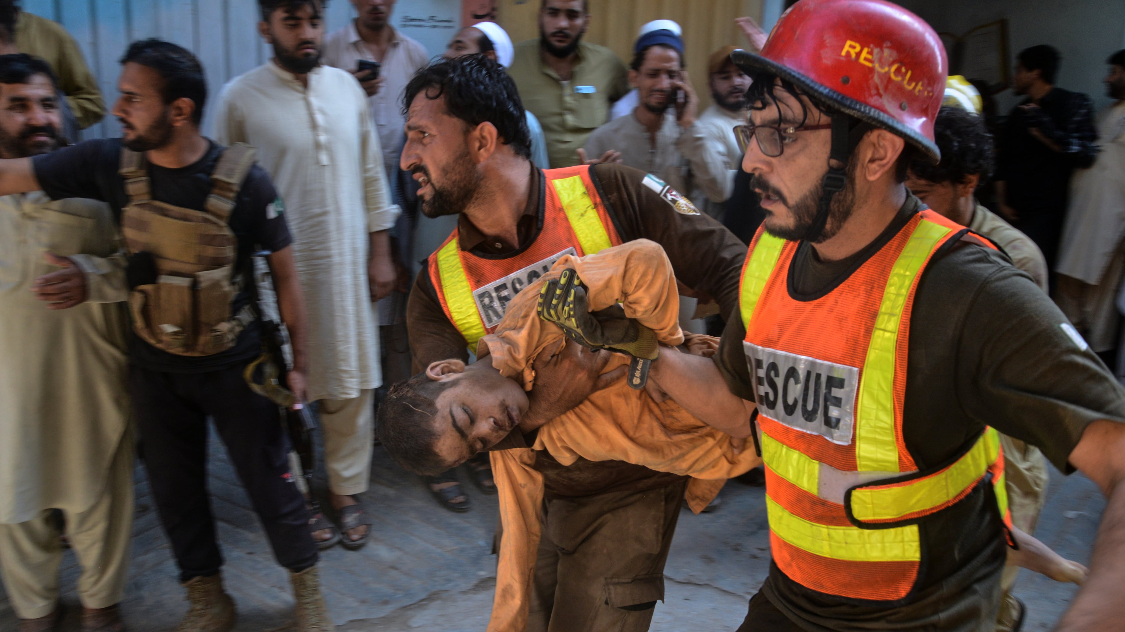 Rescue workers carry an injured boy after rescuing him from the rubble of a roof collapse at a private school, in Peshawar, Pakistan, Thursday, Oct. 15, 2026. (AP Photo/Muhammad Zubair)