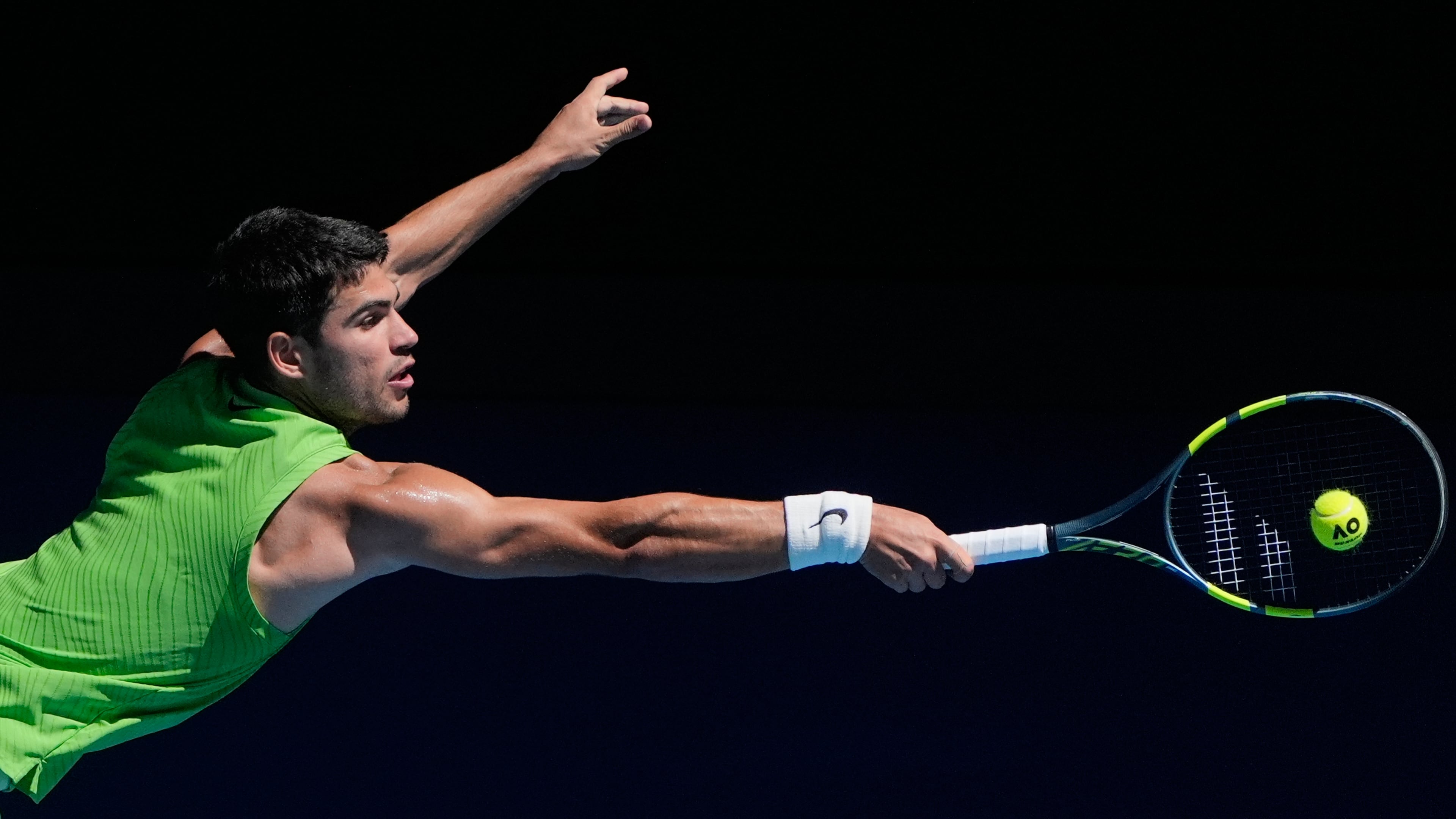 Carlos Alcaraz of Spain plays a backhand return to Corentin Moutet of France during their third round match at the Australian Open tennis championship in Melbourne, Australia, Friday, Jan. 23, 2026. (AP Photo/Asanka Brendon Ratnayake)