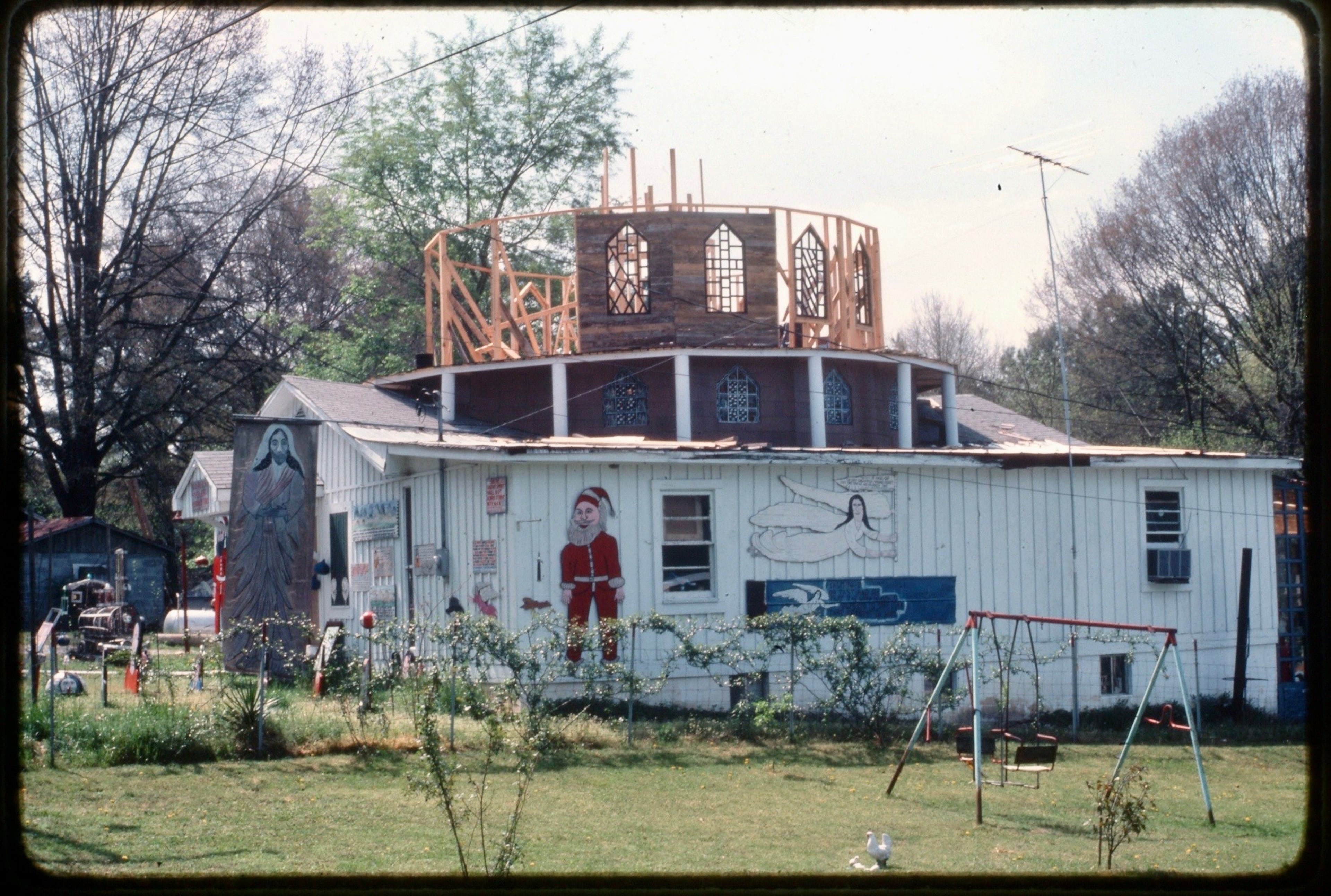 When Howard Finster purchased land in Pennville, it bordered a defunct one-story church once led by a local reverend, Billy Wright. Finster eventually purchased the church from Wright and used it as a base to build his World's Folk Art Church. Courtesy of Paradise Garden Foundation