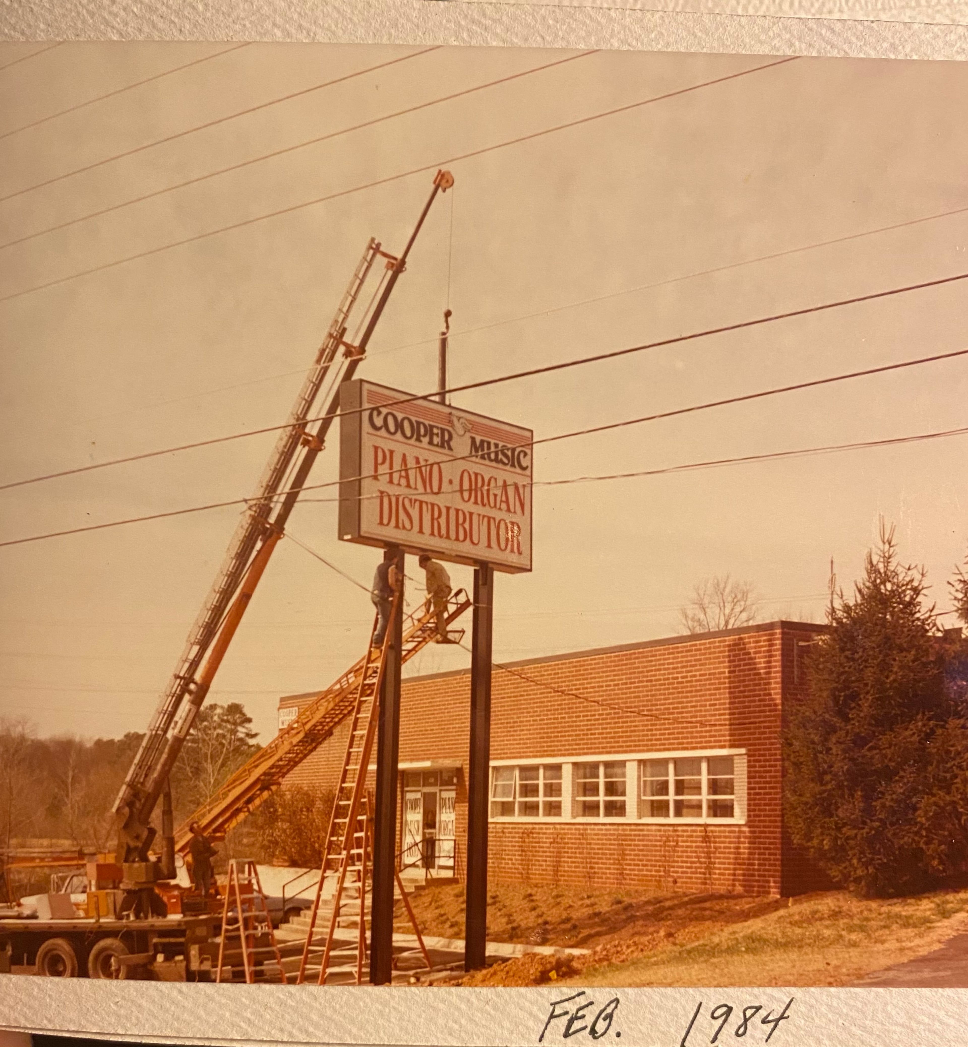 The Cooper Piano sign that towers over I-85 is shown in this Cooper family photograph from February 1984, the year the "piano in the sky" was erected. (Courtesy of Laura Cooper)