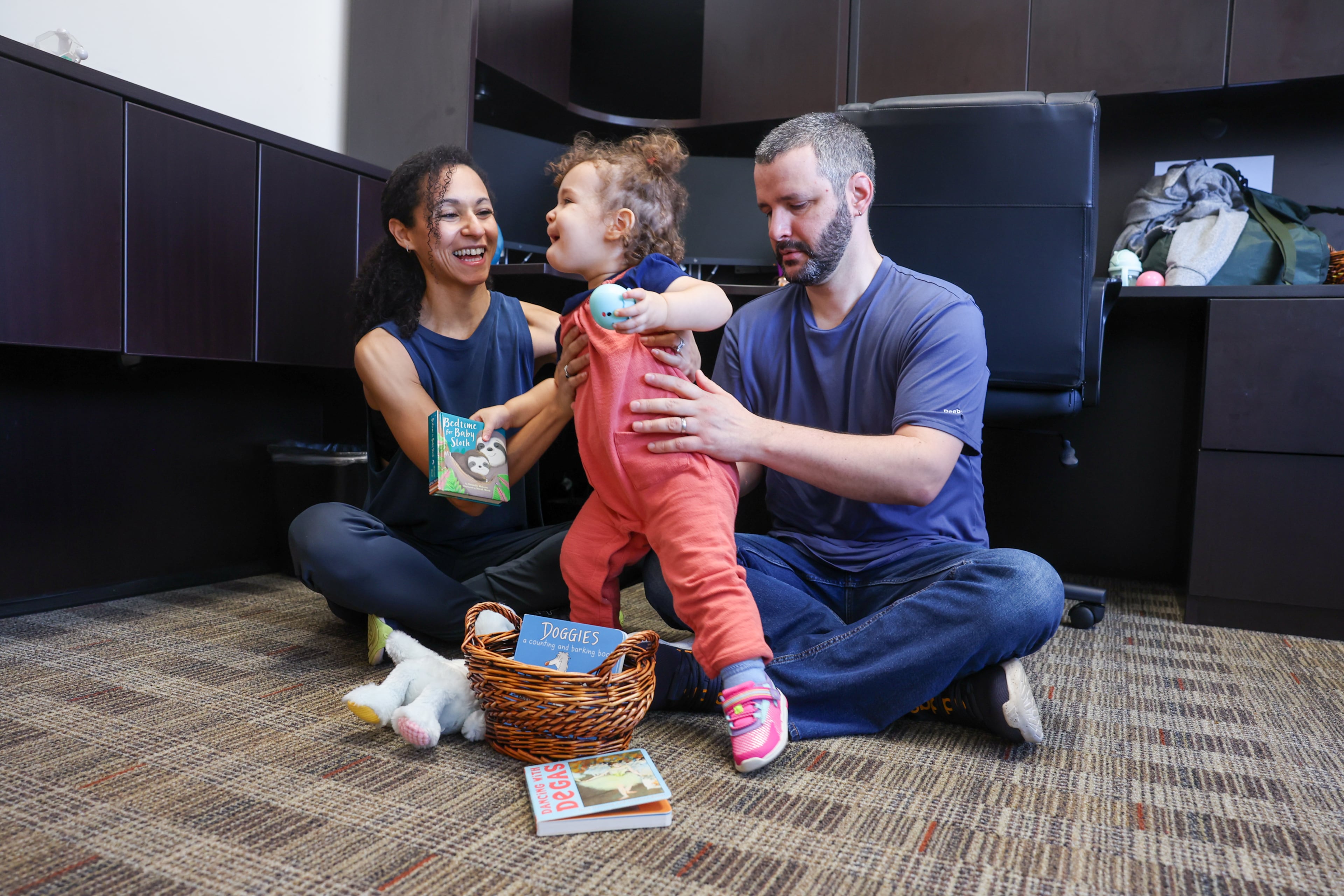 Schreier and her husband Adam (right) play with their daughter Hana in a private room outfitted for Claudia and her family caregivers at the Atlanta Ballet Michael C. Carlos Dance Centre in Atlanta on March 26, 2026. (Arvin Temkar/AJC)
