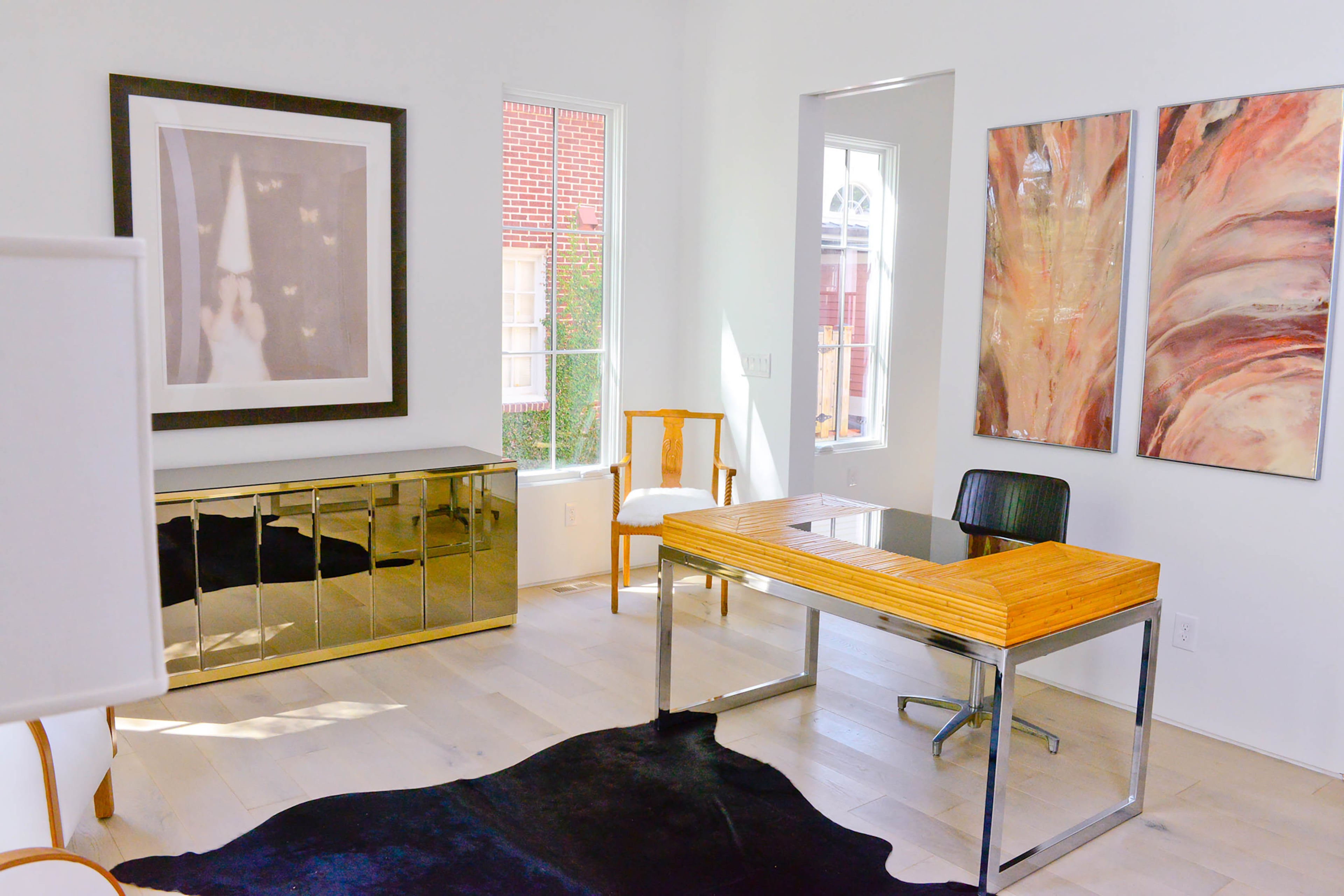 Caroline Normark used a mixture of midcentury and traditional Swedish furnishings along with artwork to add color and texture to the modern office space. In the corner, a Swedish wooden chair passed down to her husband from his grandparents is a reminder of Paul's roots. The traditional chair complements the midcentury desk from Westside Market and the vintage Ello mirrored buffet from Peachtree Battle Antiques.