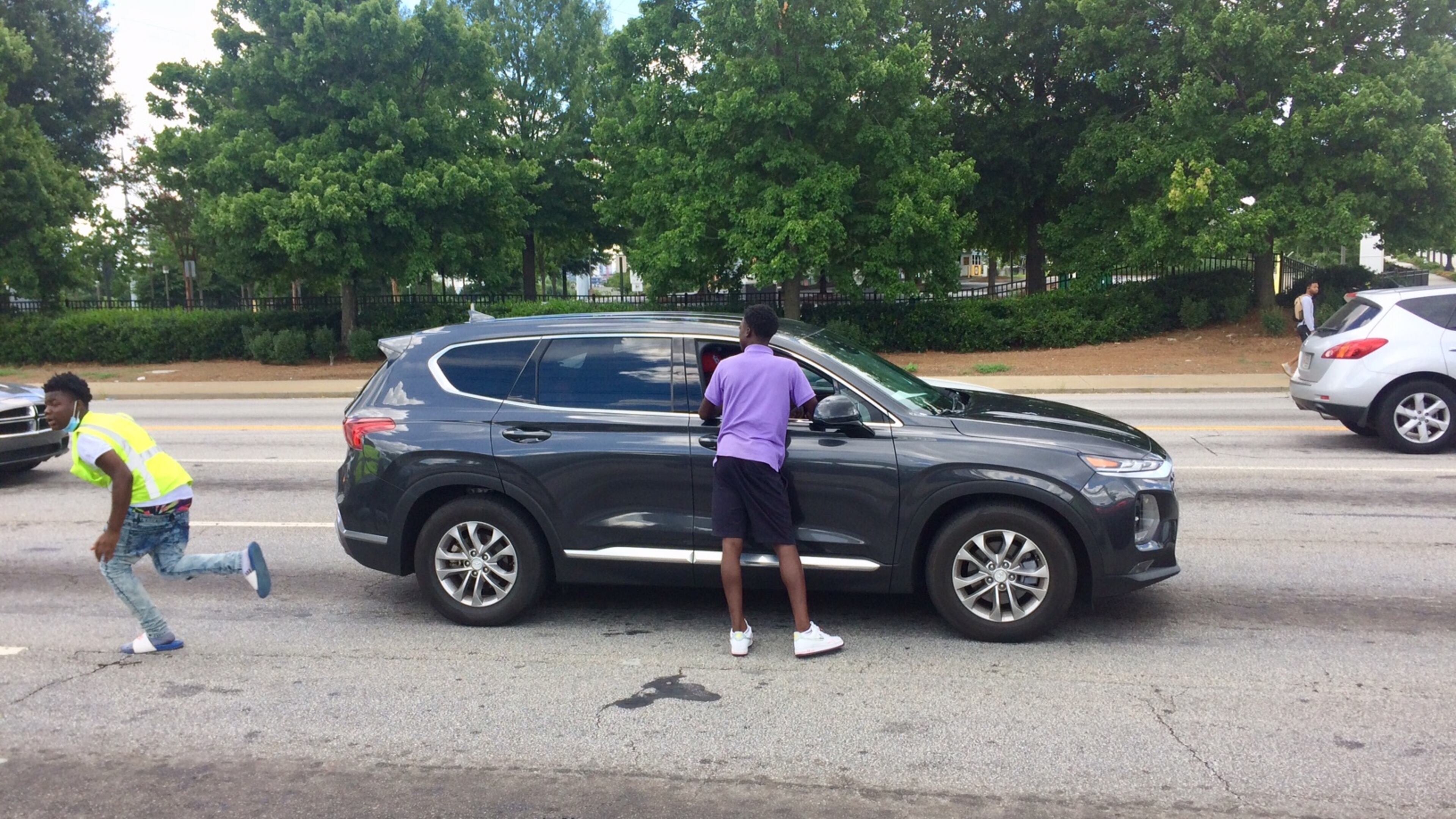 Quanarius Hosch, 15, hurries to get another bottle of water before the light changes at the corner of Northside Drive and Joseph E. Boone Blvd. Photo by BILL TORPY