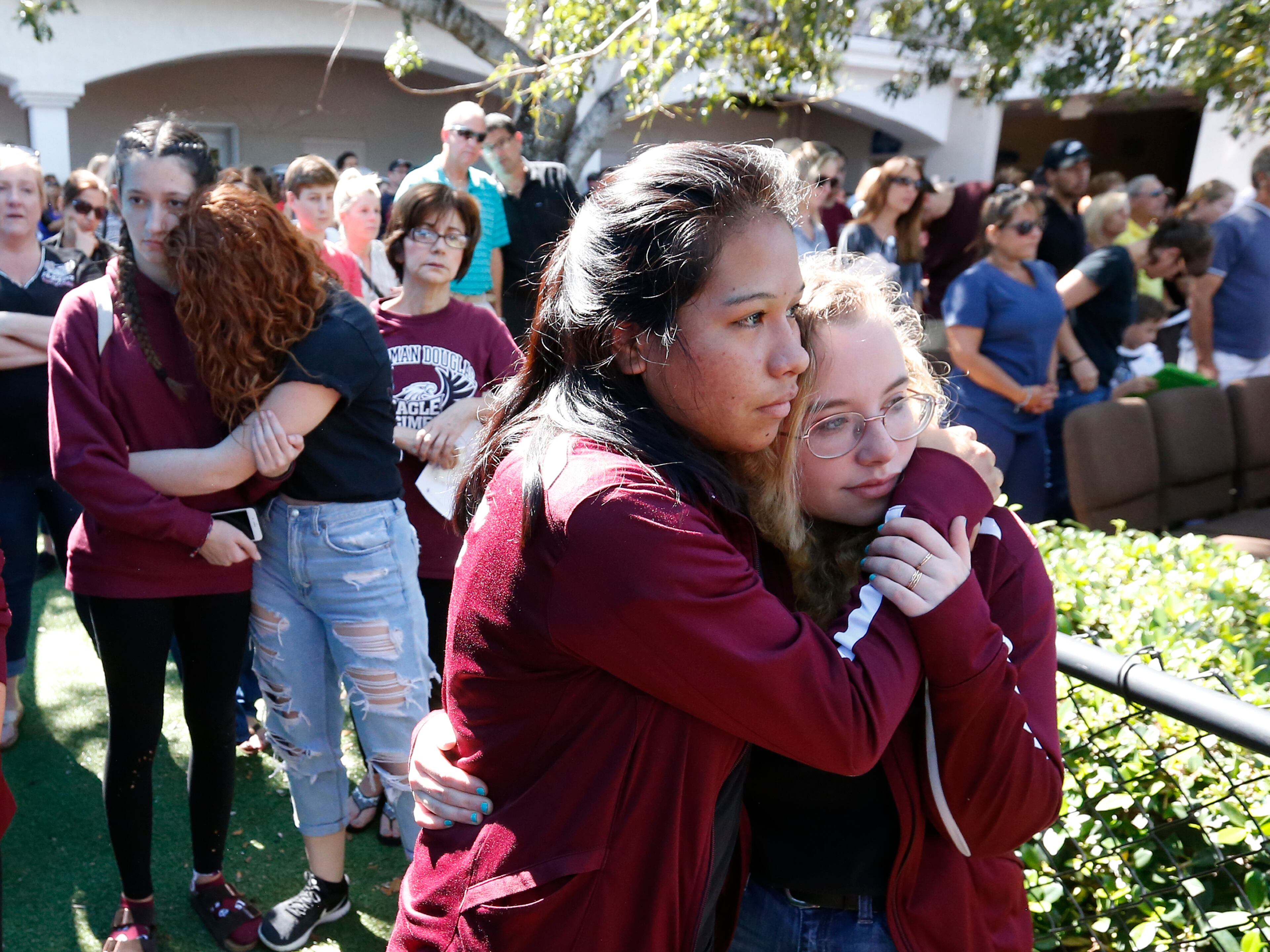 Attendees comfort each other at a vigil for the victims of the shooting at Marjory Stoneman Douglas High School at the Parkland Baptist Church, Thursday, Feb. 15, 2018 in Parkland, Fla. An orphaned 19-year-old with a troubled past and his own AR-15 rifle was charged with 17 counts of premeditated murder Thursday morning after being questioned for hours by state and federal authorities following the deadliest school shooting in the U.S. in five years. (AP Photo/Wilfredo Lee)