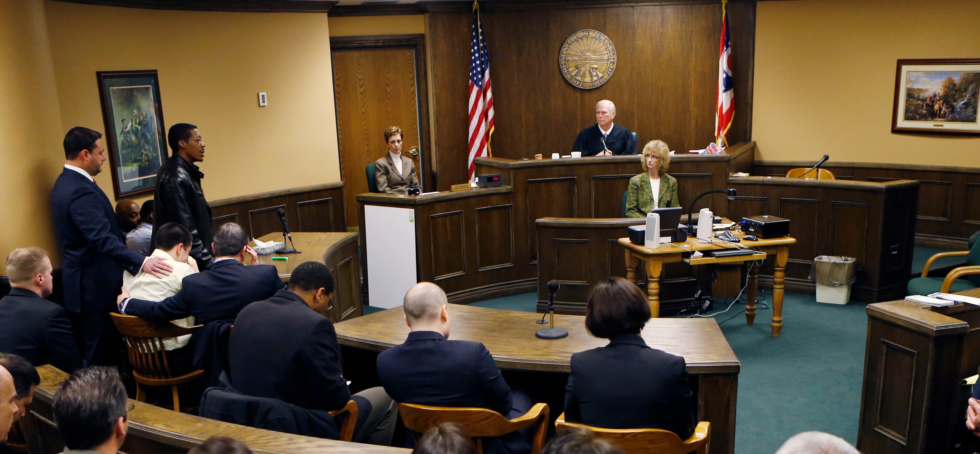 Nathaniel Richmond, the father of 16-year-old Ma'lik Richmond, standing second from left, apologizes to the victim and her family as defense attorney Adam Nemann, left, places his hand on the shoulder of his client Trent Mays, 17, after Richmond and Mays were found delinquent on rape and other charges after their trial in juvenile court in Steubenville, Ohio, Sunday.
