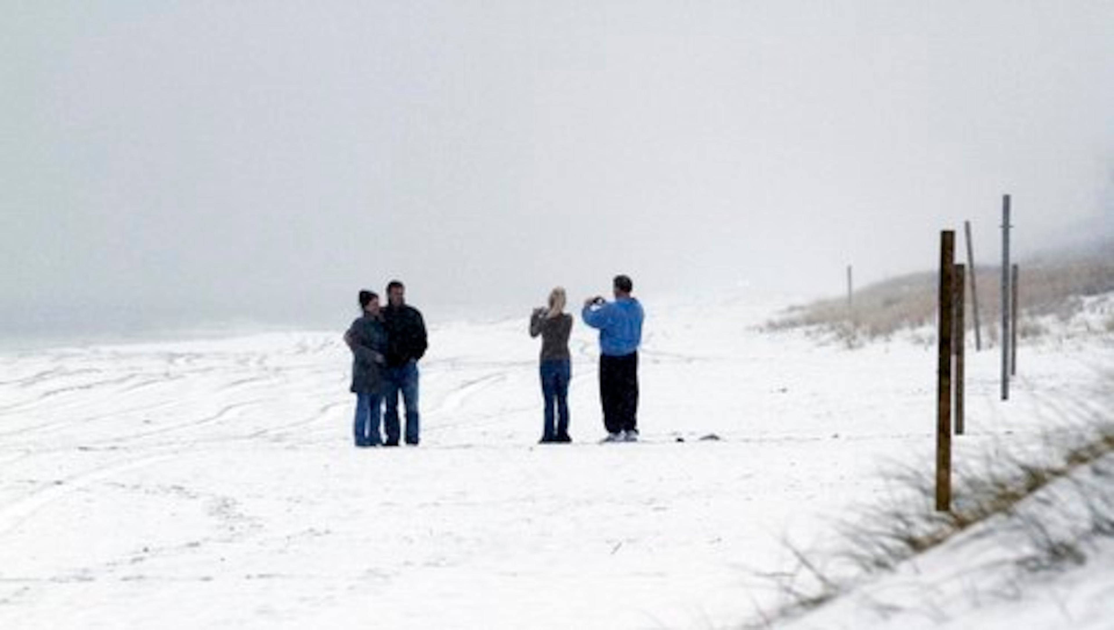 People takes photographs on the beach as a snowstorm moved through the area, Saturday, Jan. 22, 2011 in Emerald Isle, N.C.