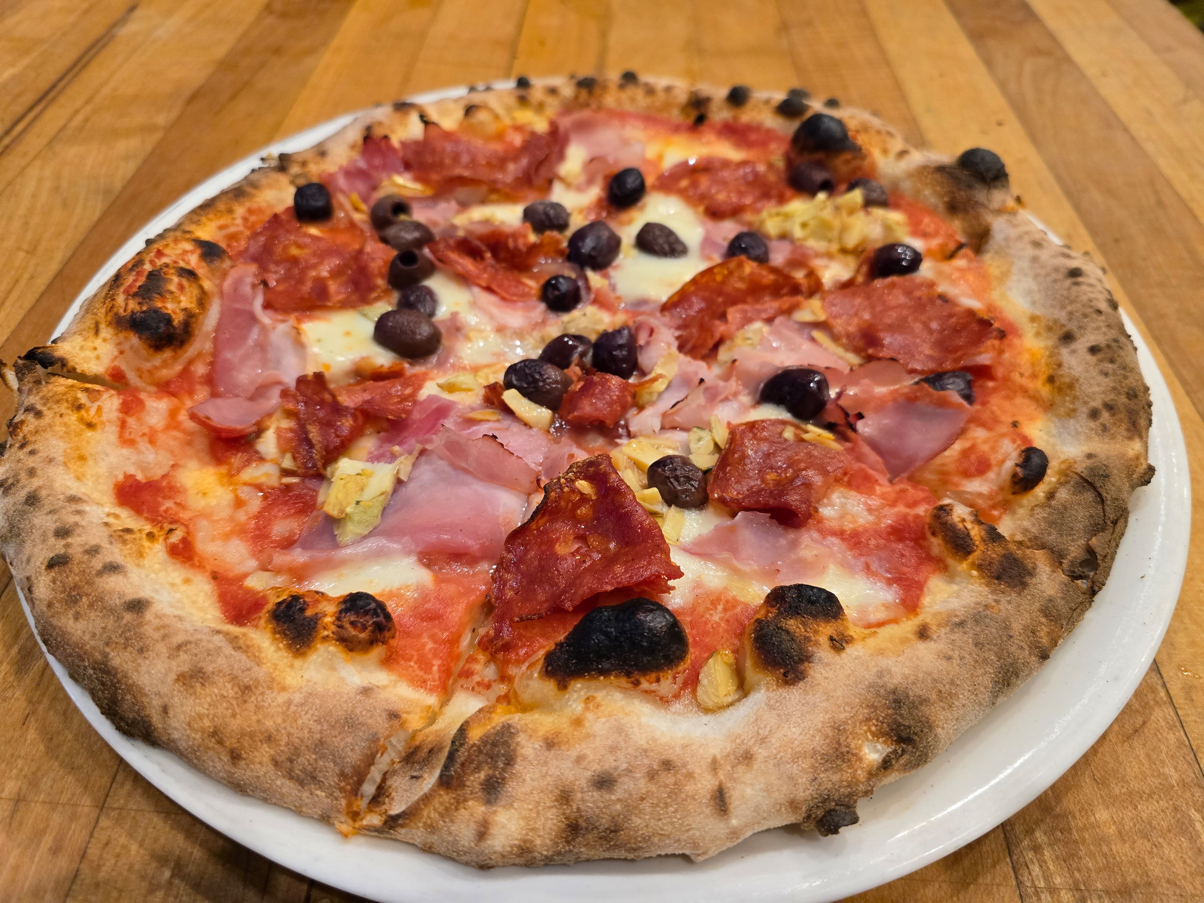 Novo Cucina’s capricciosa pizza holds a punchy combination of cotto ham, salami, artichokes, olives and mozzarella. (Courtesy of Novo Cucina)