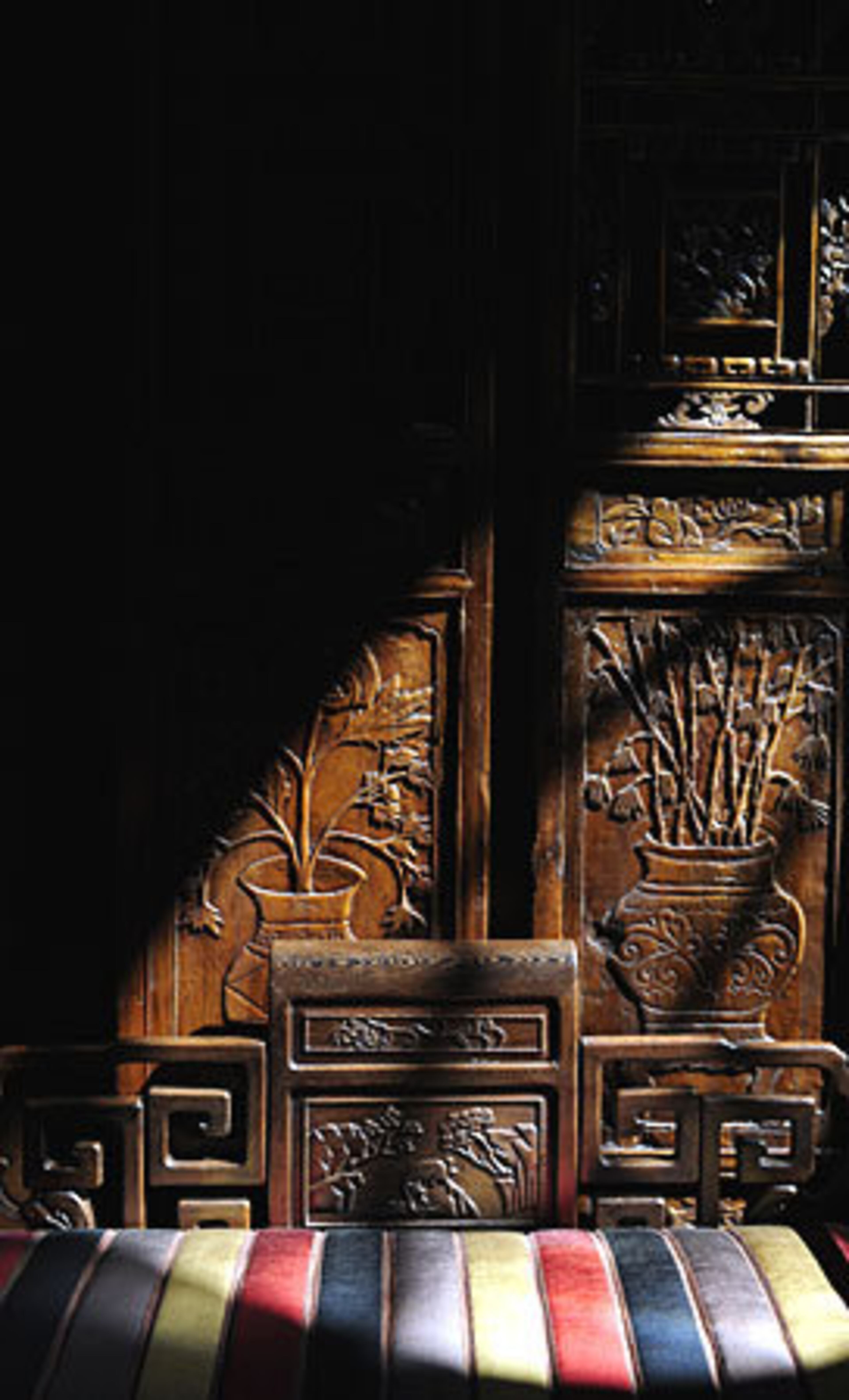 This intricately carved bench greets visitors to the Rogers home in its front foyer. Its Asian styling signals the international influence that informs Kenny Rogers' decor preferences. He describes his style as "high-end eclectic. I love Chinese. I love Italian. And in almost every house I have had, I have an African Room."