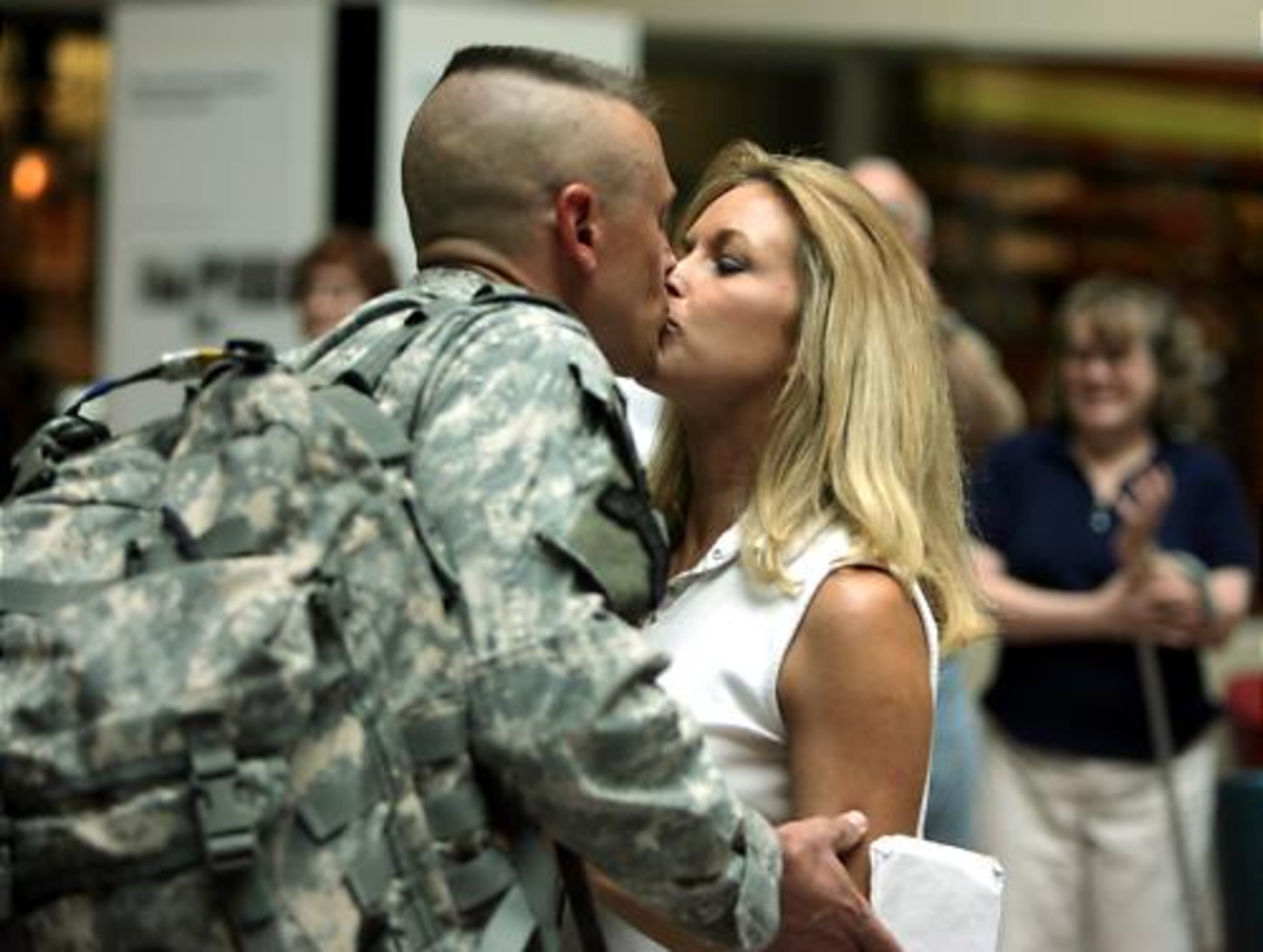 Staff Sgt. Adam Troxel gets a last goodbye kiss from his wife, Holly Troxel, before processing for return to Iraq.