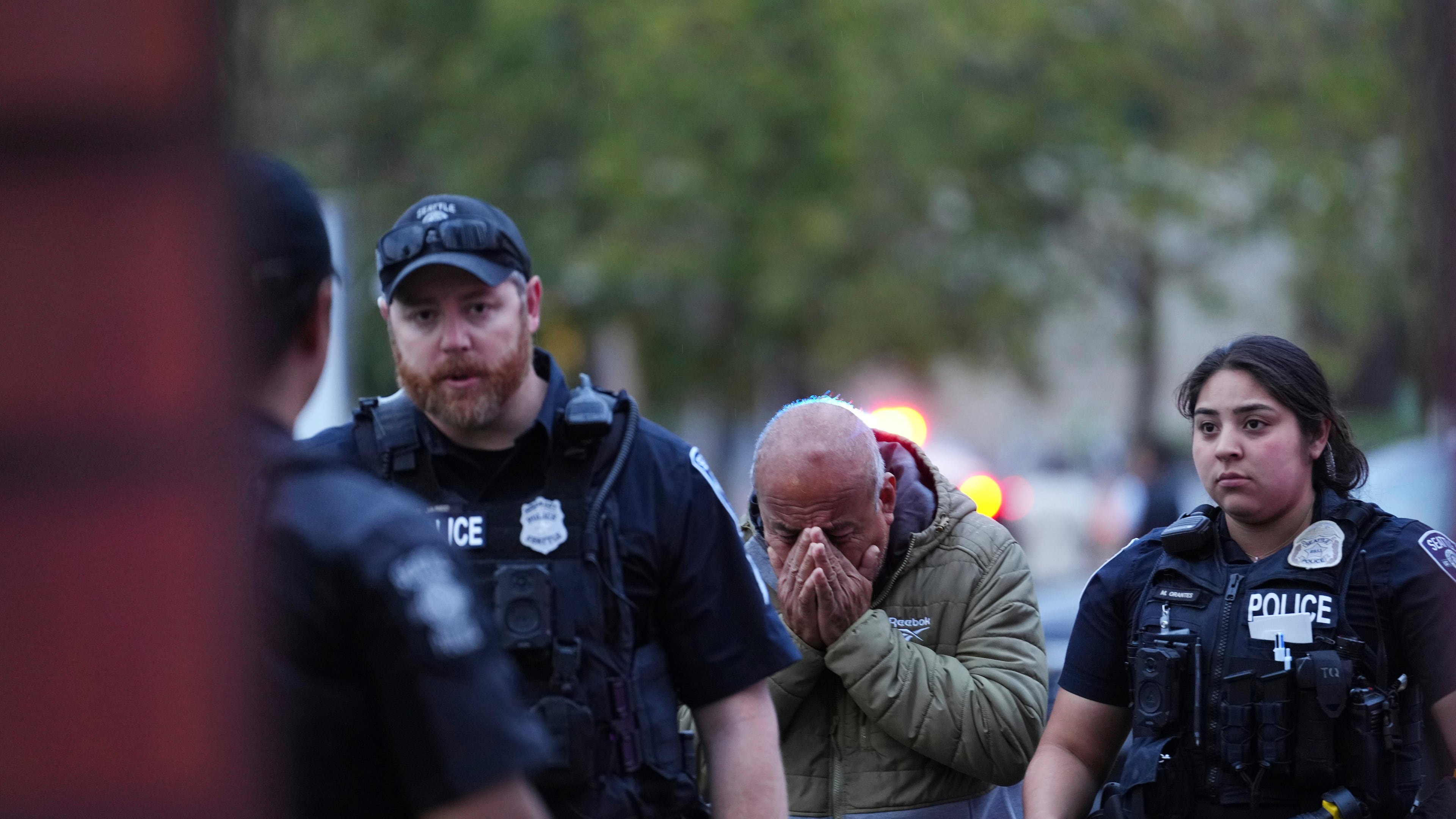 An unidentified man is led into the scene by police after they responded to a shooting at Seattle Center during the Bite of Seattle food festival Sunday, July 26, 2026, in Seattle, Wash. (AP Photo/Lindsey Wasson)