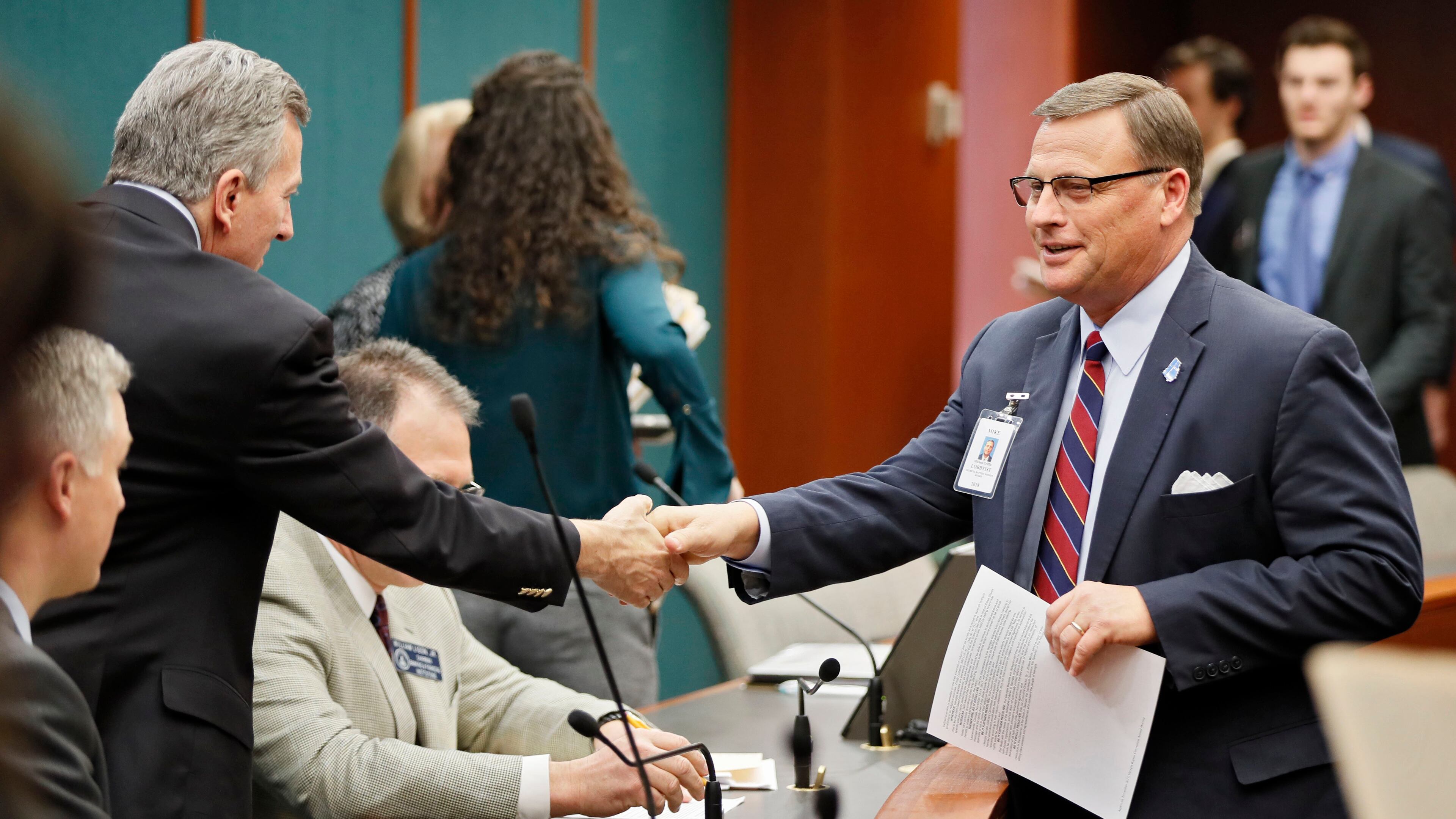 2/8/18 - Atlanta - Mike Griffin (right), lobbyist for the Georgia Baptist Mission Board, greets members of the committee before a committee hearing on a bill that would permit adoption agencies to turn away same-sex couples. The full Senate Judiciary Committee, chaired by Sen. Jesse Stone (left) could vote Tuesday on the bill. BOB ANDRES /BANDRES@AJC.COM