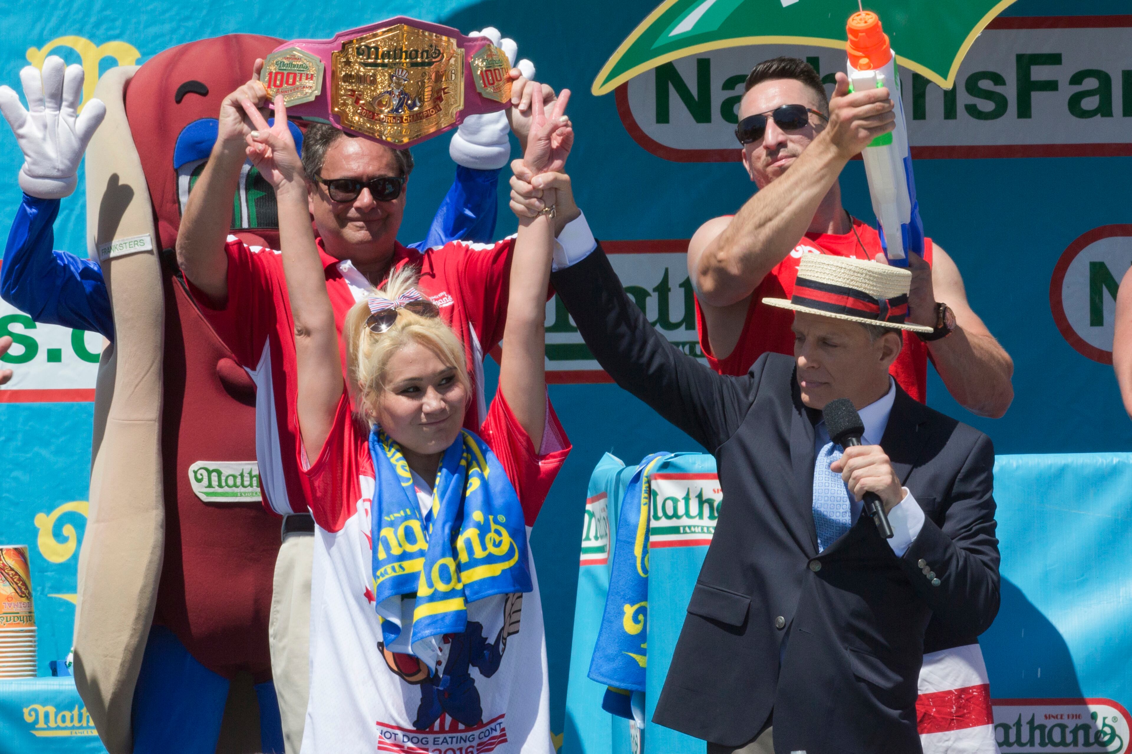 Miki Sudo, left, is declared the winner in Nathan's Famous Fourth of July International Hot Dog Eating Contest Woman's competition, Monday, July 4, 2016, in New York. Sudo came in first eating 38.5 hot dogs and buns in 10 minutes. (AP Photo/Mary Altaffer)