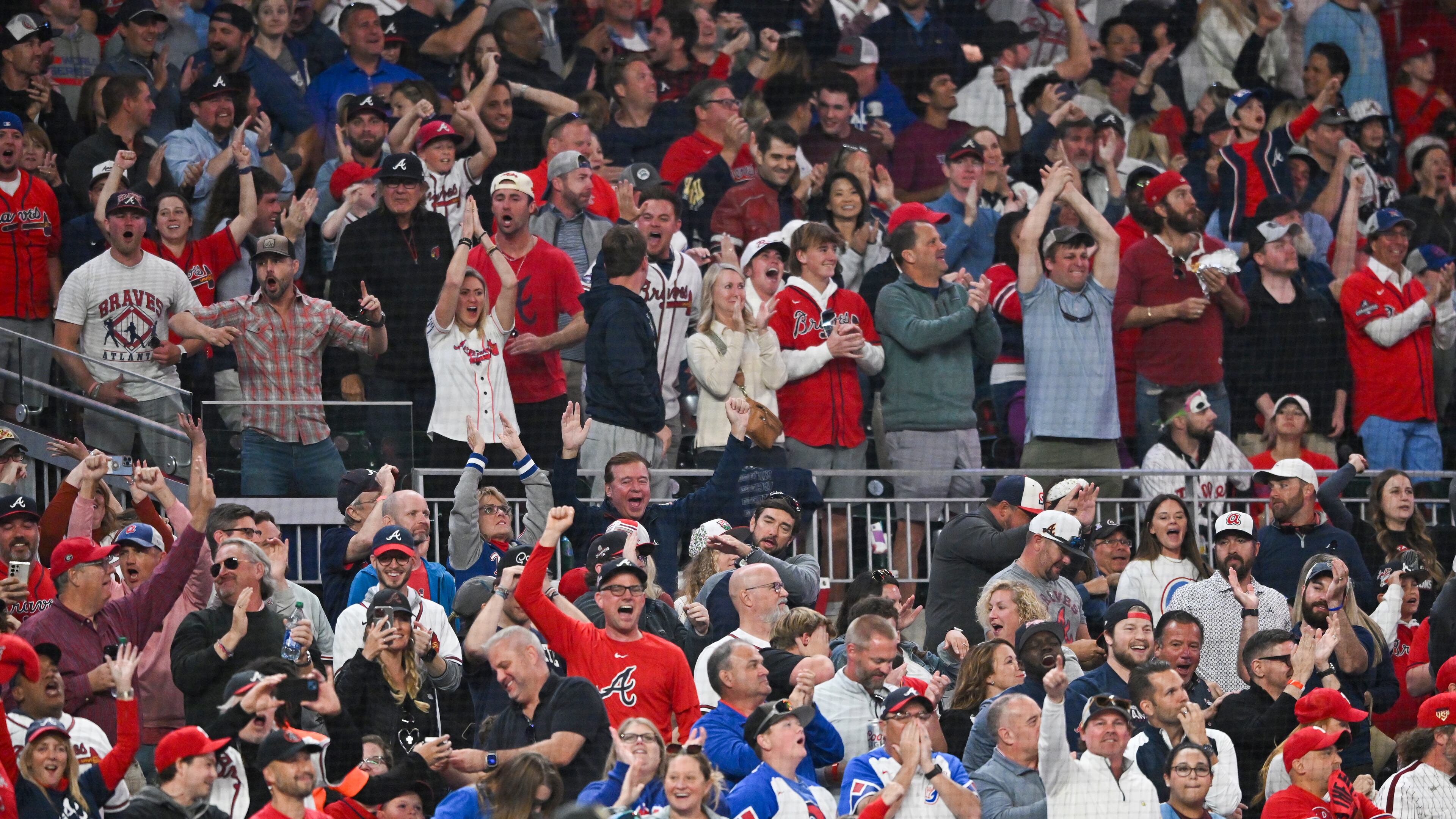 Fans cheer as Atlanta Braves catcher Travis d'Arnaud hits a two-run home run against the Philadelphia Phillies during the seventh inning of NLDS Game 2 in Atlanta on Monday, Oct. 9, 2023. (Hyosub Shin / Hyosub.Shin@ajc.com)