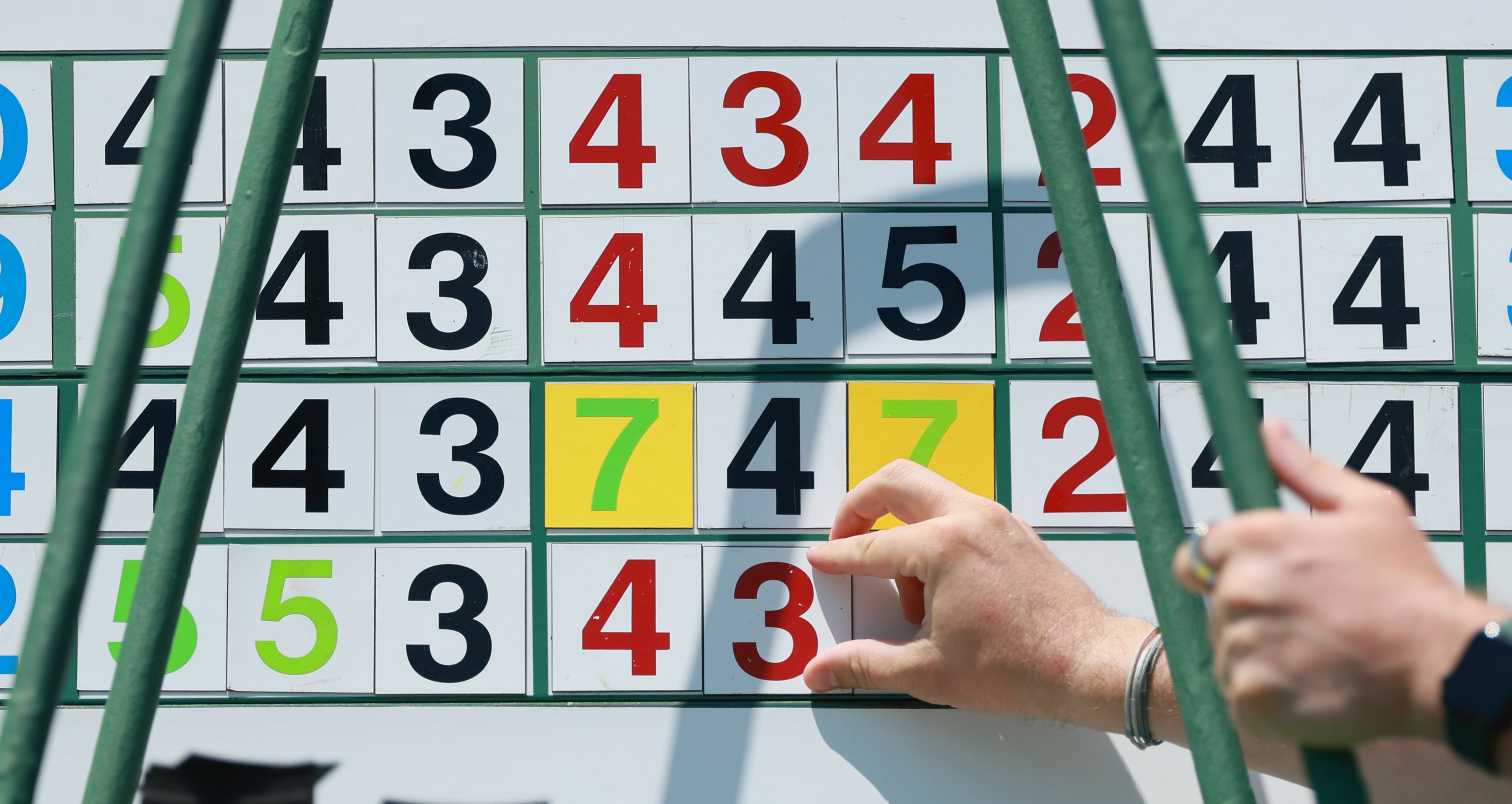 Workers maintain the main scoreboard near the first fairway during the final round of the Masters at Augusta National on Sunday, April 12, 2026, in Augusta, Ga. (Jason Getz/AJC)