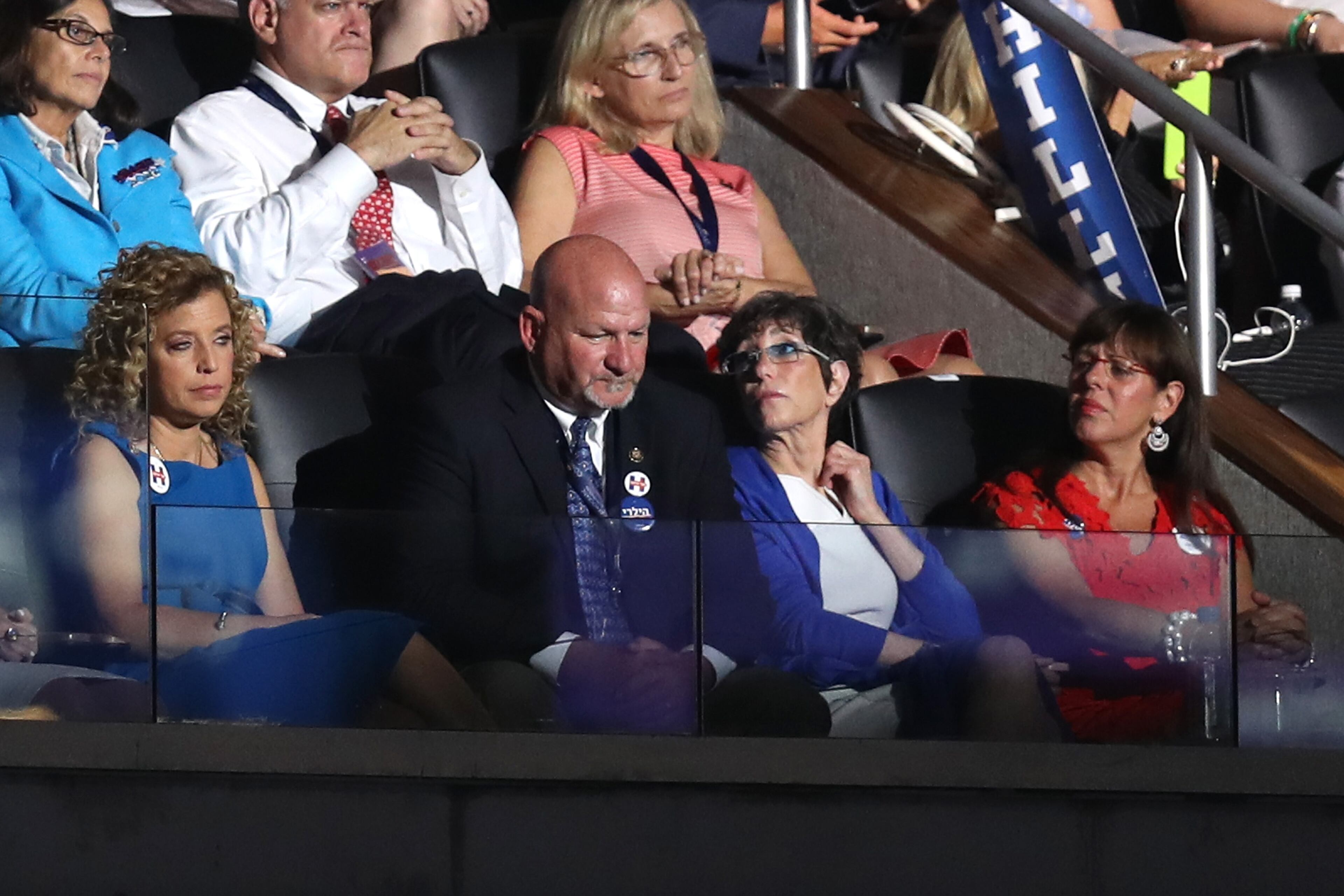 Outgoing chairperson of the Democratic National Committee Debbie Wasserman Schultz (left) along with her husband Steve Schultz (center) listen to Democratic presidential candidate Hillary Clinton speak on the fourth day of the Democratic National Convention at the Wells Fargo Center, July 28, 2016 in Philadelphia. (Photo by Joe Raedle/Getty Images)