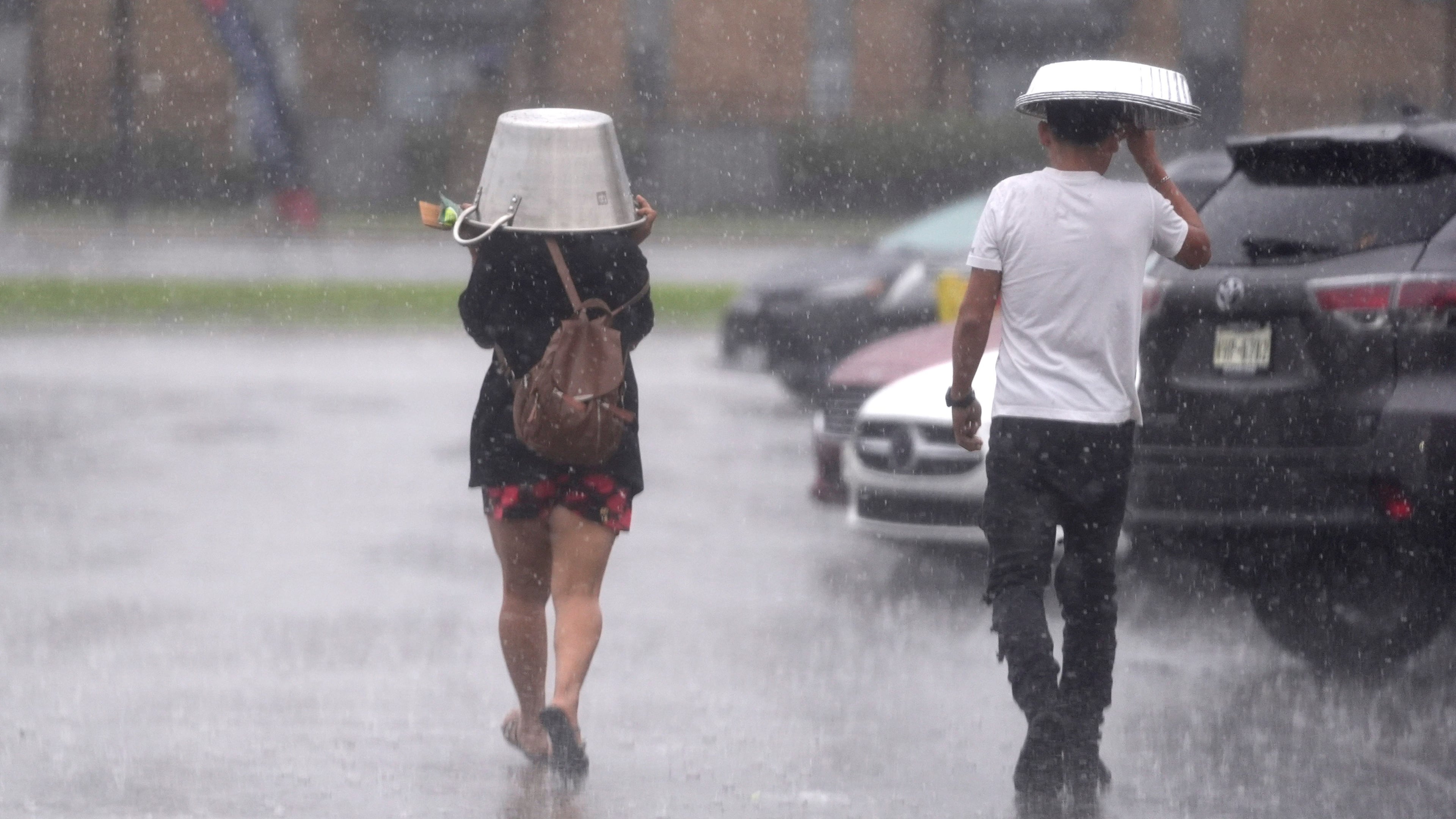 FILE - People cover up from falling rain Dec. 24, 2024, in Dallas. (AP Photo/LM Otero, File)