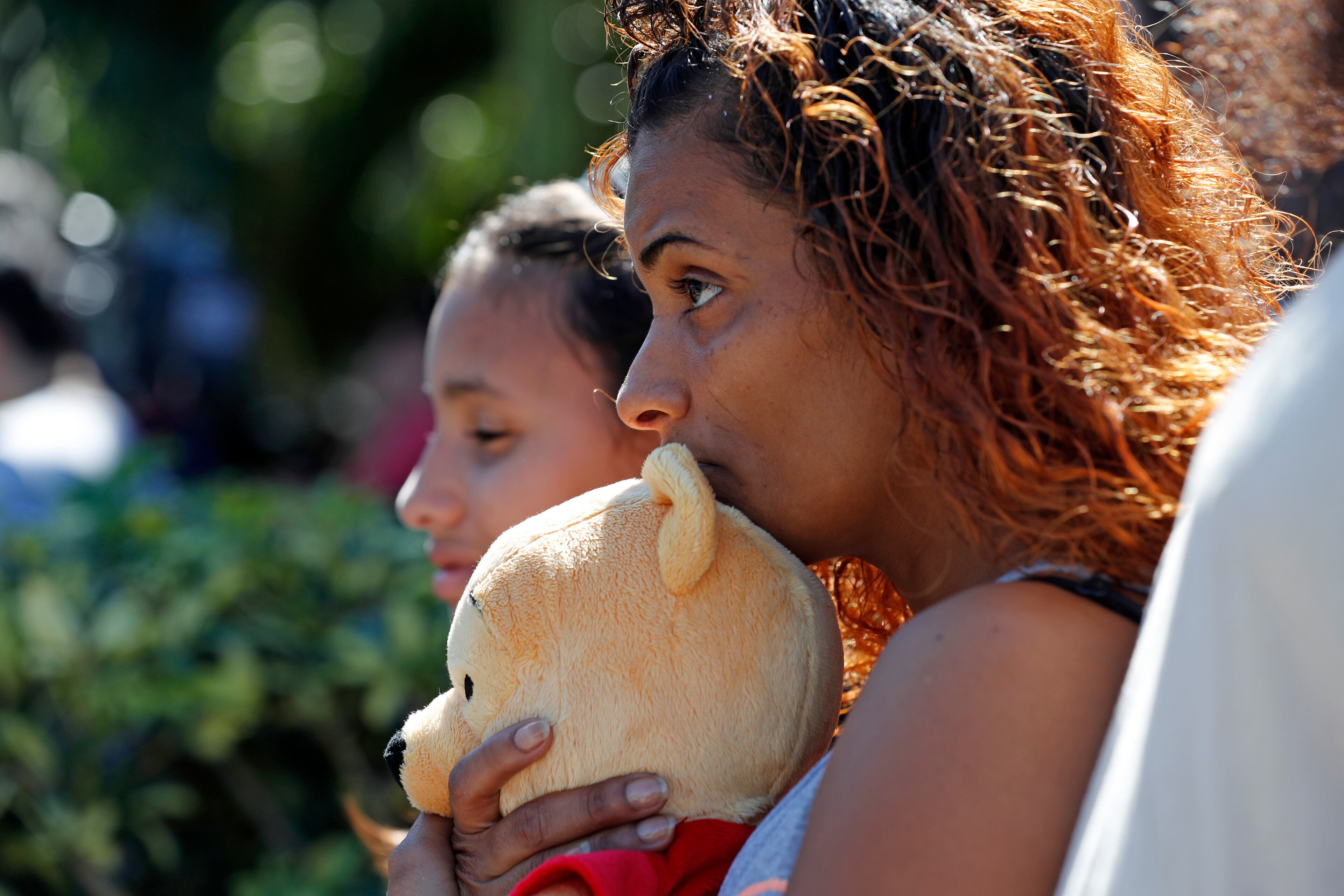 Veronica Laureano, holds a teddy bear as she attends a vigil with her daughter Zorayha Laureano, 11, at the Parkland Baptist Church, for the victims of the Wednesday shooting at Marjory Stoneman Douglas High School, in Parkland, Fla., Thursday, Feb. 15, 2018. Nikolas Cruz, a former student, was charged with 17 counts of premeditated murder on Thursday. (AP Photo/Gerald Herbert)