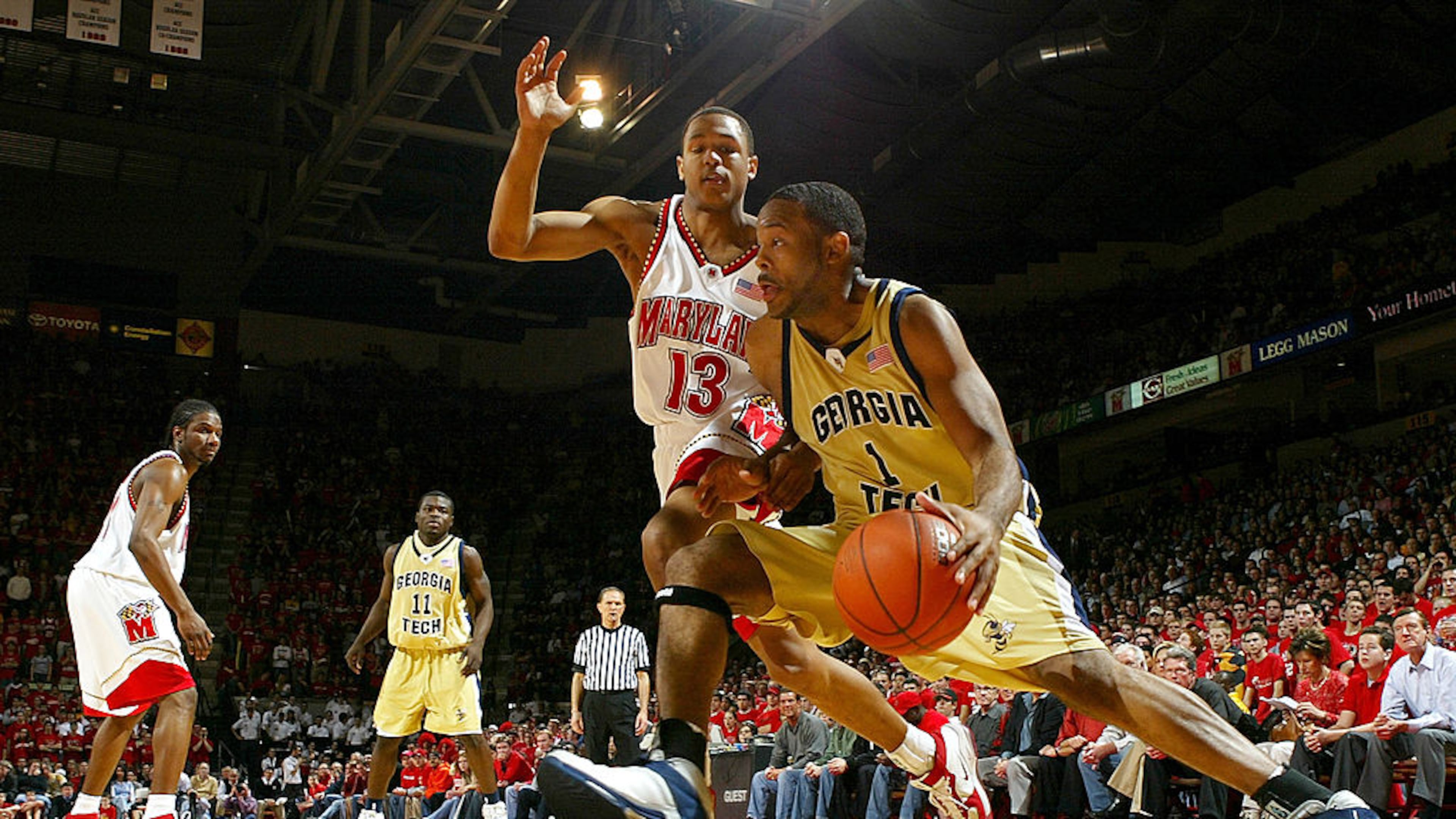 COLLEGE PARK, MD - FEBRUARY 19: B.J. Elder #1 of the Georgia Tech Yellow Jackets drives the baseline around Chris McCray #13 of the Maryland Terrapins during ACC basketball action on February, 2004 at the Comcast Center in College Park, Maryland. (Photo by Doug Pensinger/Getty Images)