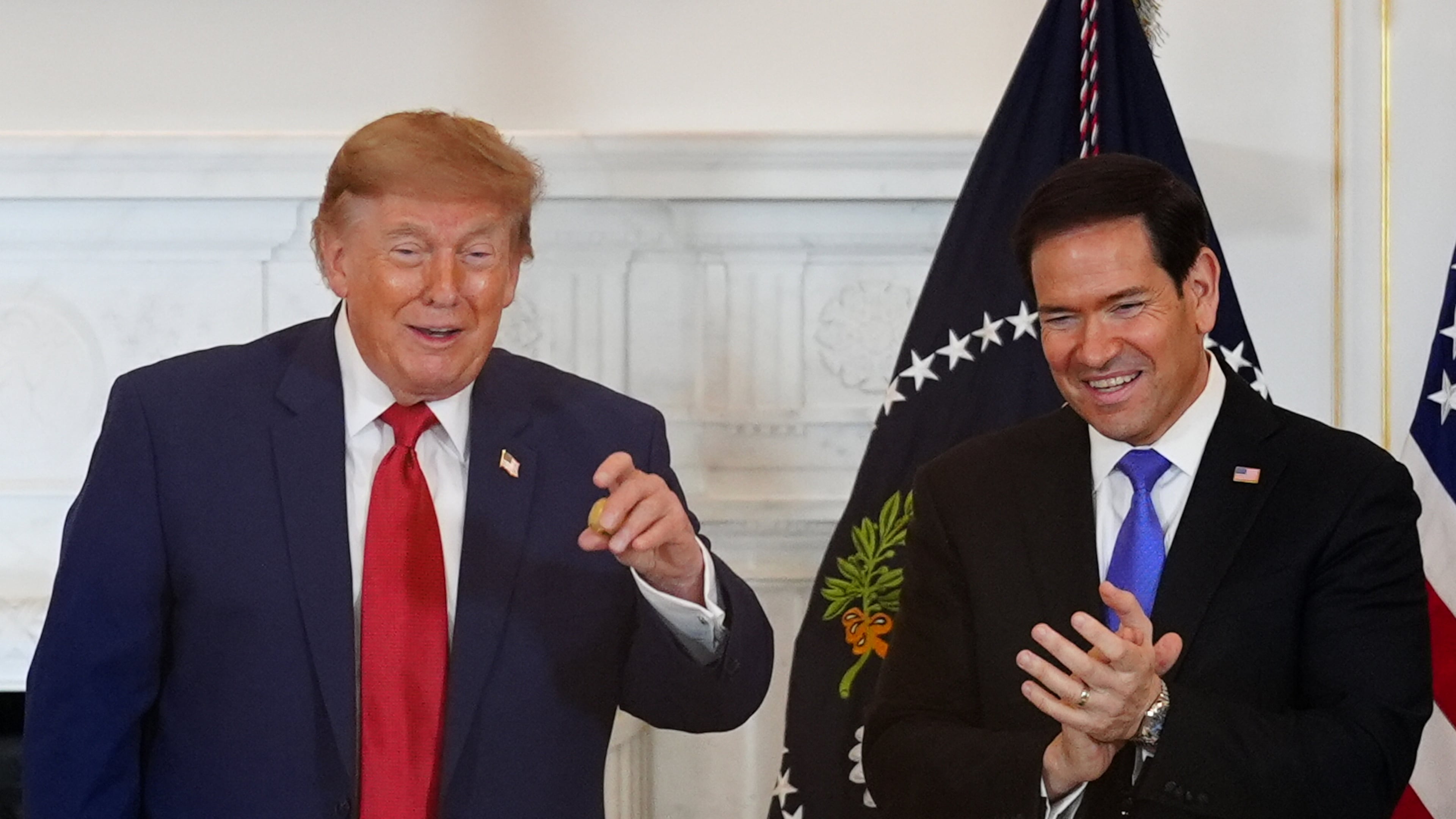 President Donald Trump holds a gold nugget he was presented as Secretary of State Marco Rubio watches during a roundtable on the American mining industry, Friday, Aug. 7, 2026, at the State Department in Washington. (AP Photo/Julia Demaree Nikhinson)