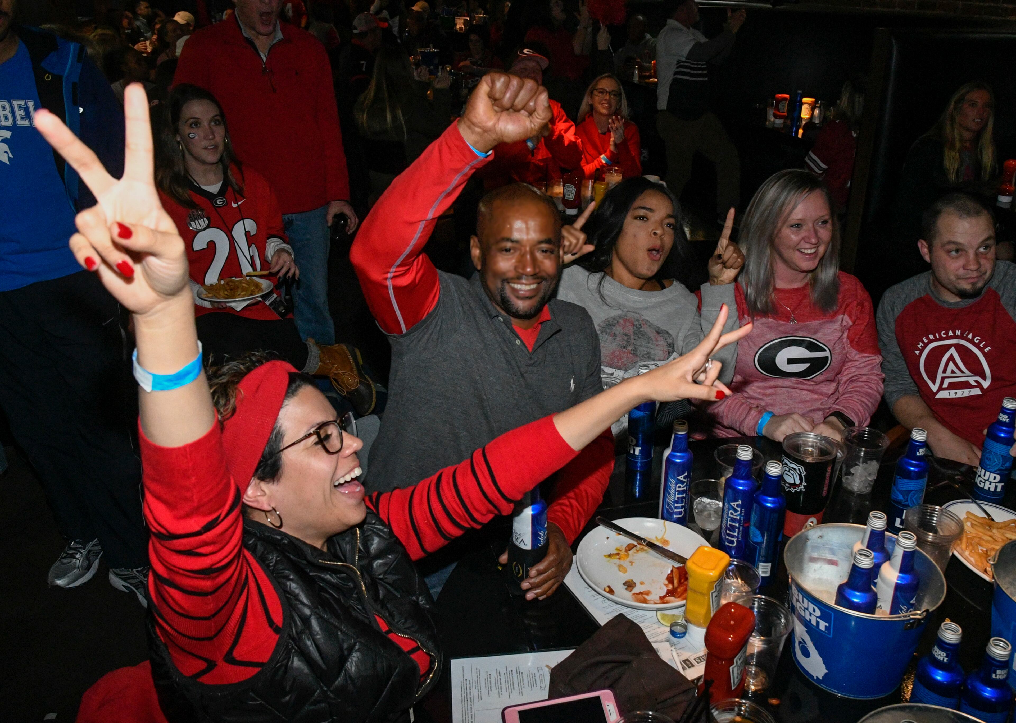 Former UGA football player who played in the 1984 Cotton Bowl, second from left, revels with wife Daniella Moss, and others while watching the College Football National Championship game against Alabama at a restaurant on Monday Jan. 8, 2018, in Atlanta. (John Amis)