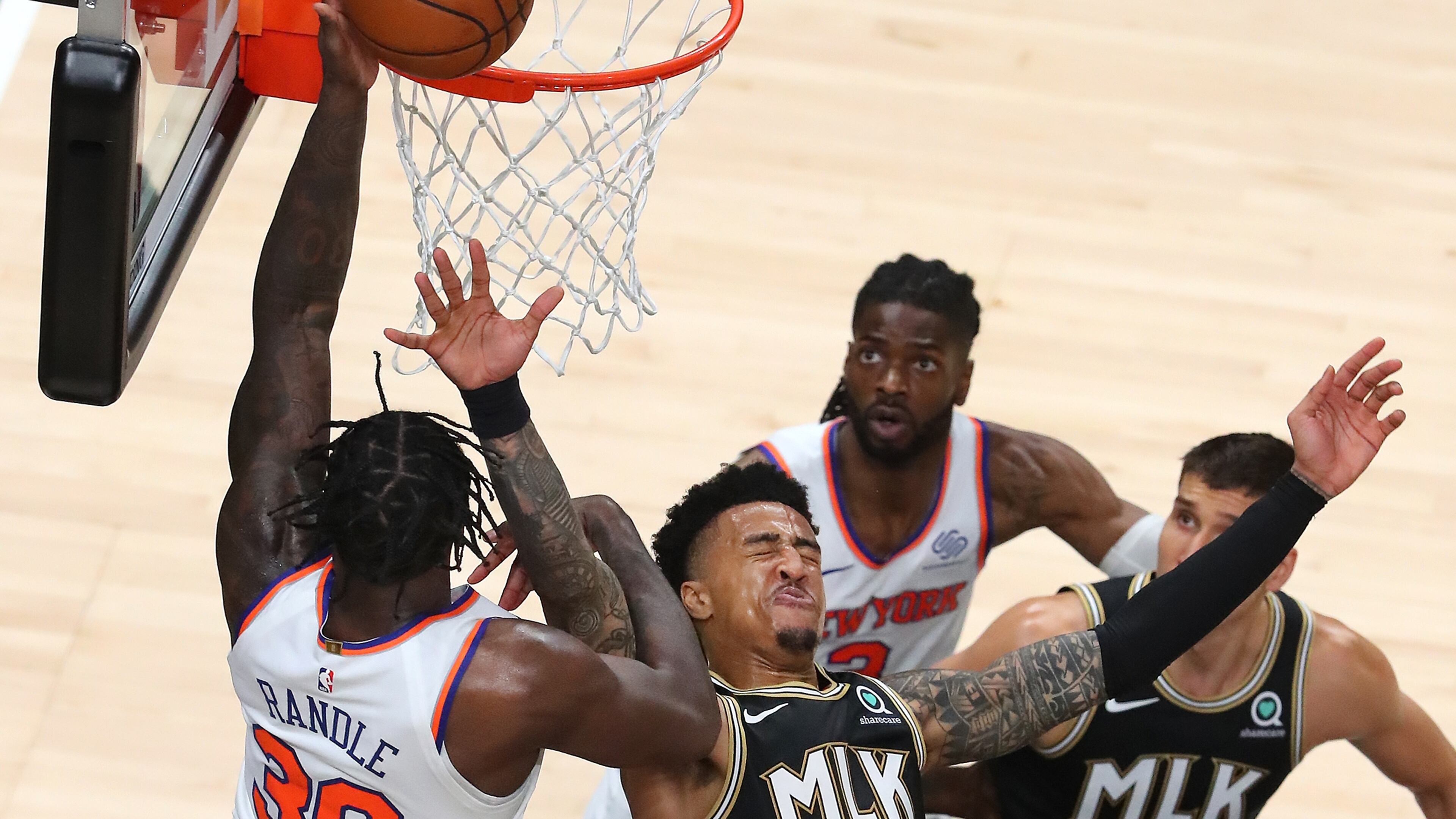 Hawks forward John Collins takes an elbow in the face having to leave the game with a bloody mouth for medical attention on a foul from New York Knicks forward Julius Randle during Game 4 of their first-round NBA playoff matchup Sunday, May 30, 2021, at State Farm Arena in Atlanta. (Curtis Compton / Curtis.Compton@ajc.com)