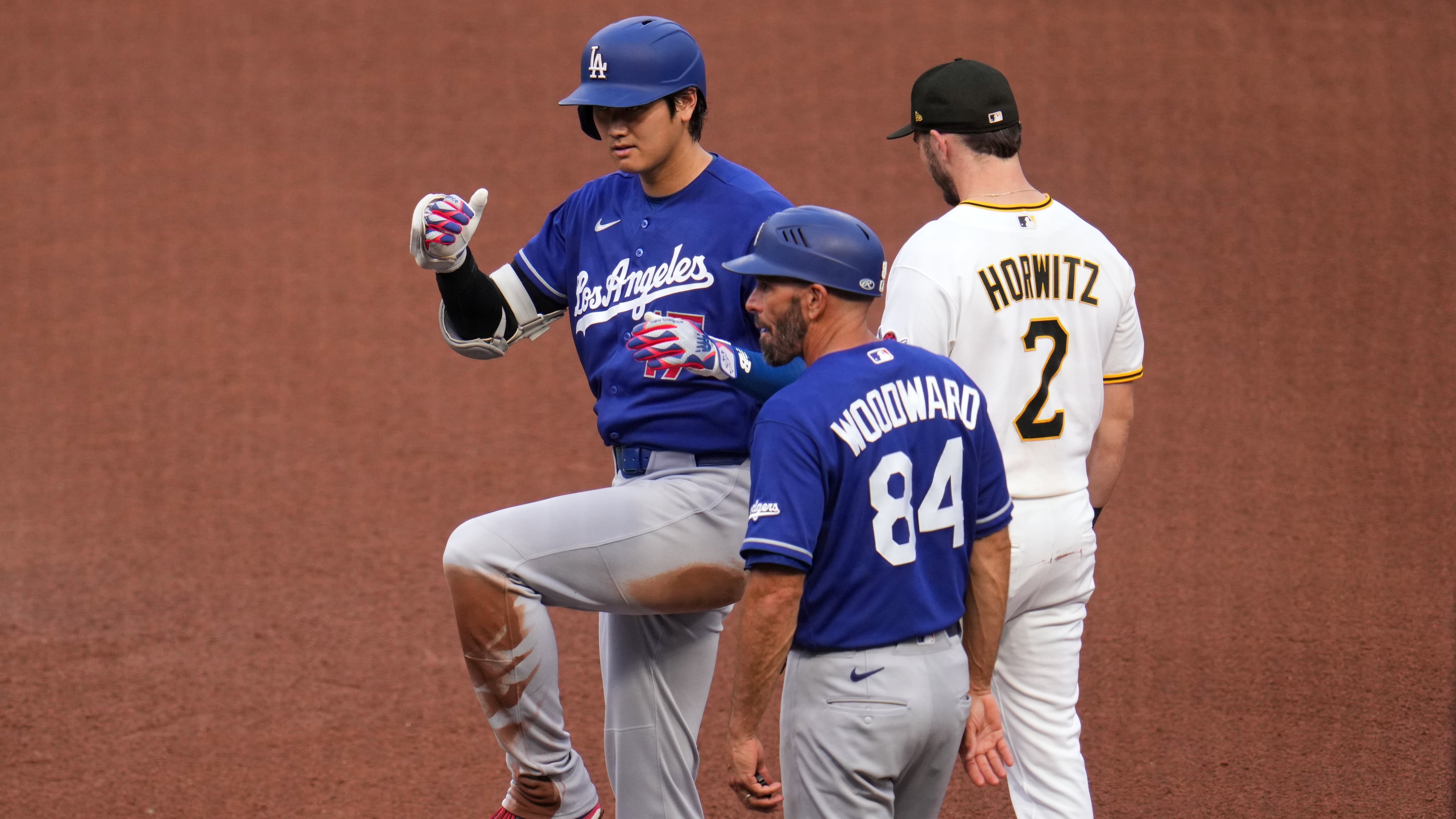 Los Angeles Dodgers' Shohei Ohtani, left, celebrates as he stands on first base after hitting a single off Pittsburgh Pirates pitcher Mitch Keller during the fourth inning of a baseball game in Pittsburgh, Thursday, June 11, 2026. (AP Photo/Gene J. Puskar)