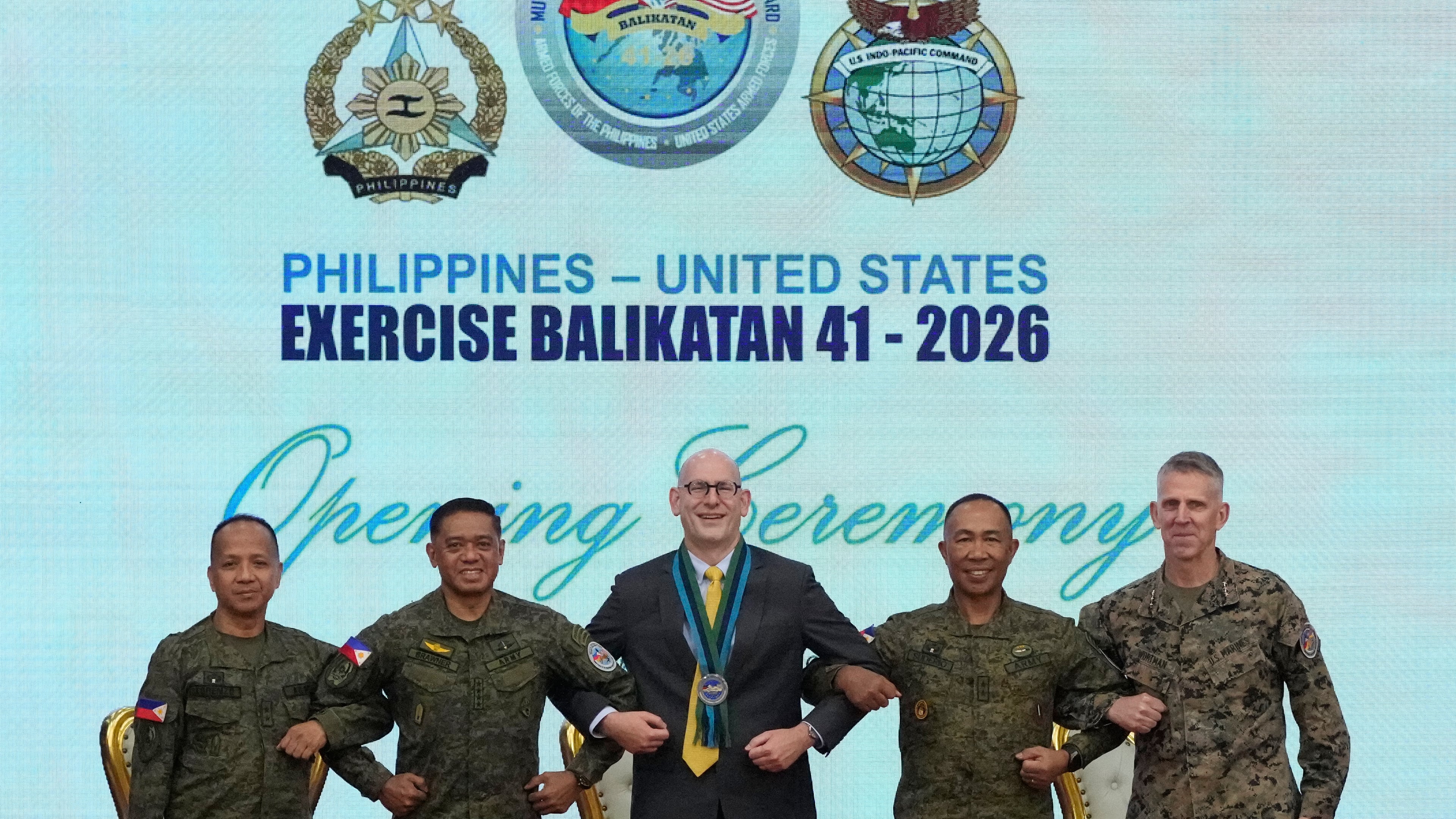 From left, Major General Francisco Lorenzo Jr., Philippine exercise director, Philippine military Chief General Romeo Brawner, U.S. Charge d' Affaires, Ad interim Y. Robert Ewing, Philippine Deputy Chief of Staff for Operations J3 Major General Elmer Suderio and US Lieutenant General Christian Wortman, Commanding General I Marine Expeditionary Force, pose during the opening ceremonies of the joint military exercise dubbed "Balikatan" or "Shoulder to Shoulder", Monday, April 20, 2026, at Camp Aguinaldo military headquarters in Quezon city, Philippines. (AP Photo/Aaron Favila)