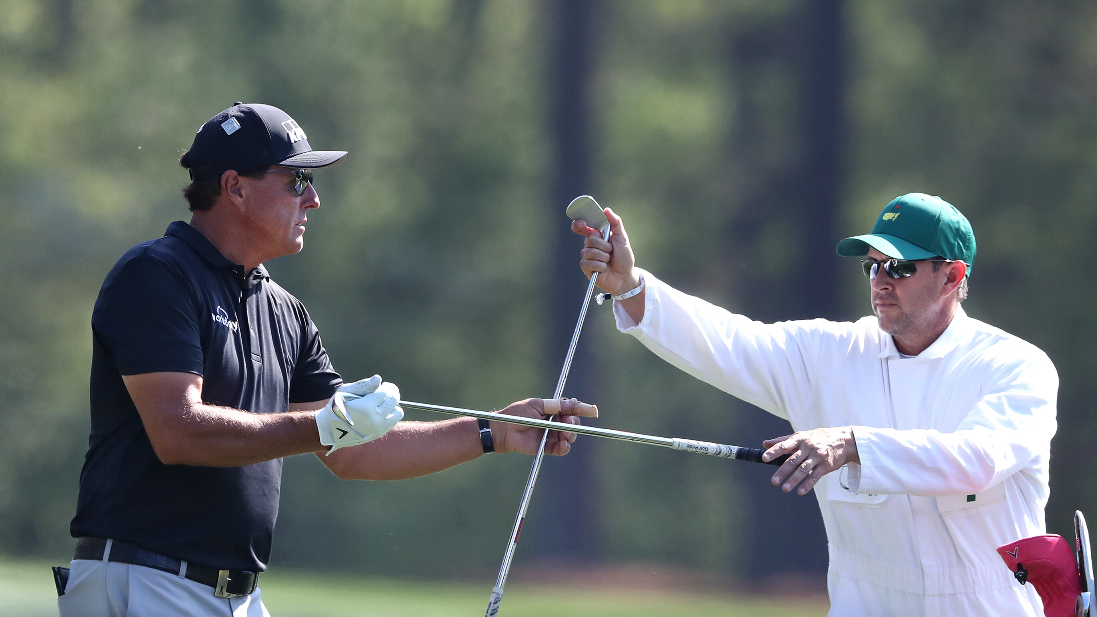 Phil Mickelson changes his club selection with his caddy Tim Mickelson on the 12th tee during his practice round for the Masters at Augusta National Golf Club on Tuesday, April 6, 2021, in Augusta. Curtis Compton / Curtis.Compton@ajc.com