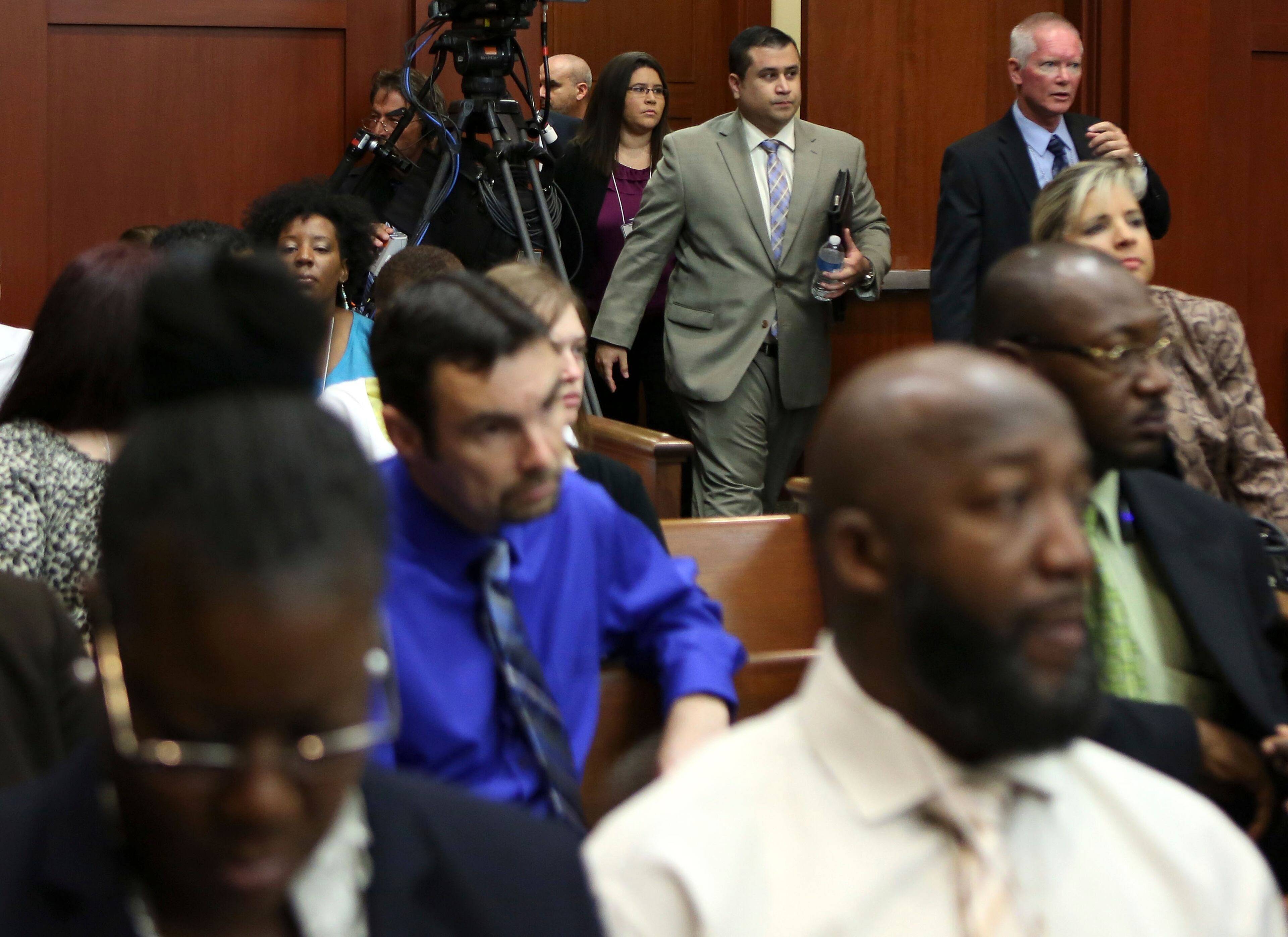 George Zimmerman, center rear, enters the courtroom for his trial in Seminole circuit court, July 5, 2013 in Sanford, Fla. His sister Gracie follows behind. Zimmerman has been charged with second-degree murder for the 2012 shooting death of Trayvon Martin. Martin's parents Sybrina Fulton, left, foreground and Tracy Martin, right foreground, sit in the audience. (AP Photo/Orlando Sentinel, Gary W. Green, Pool)
