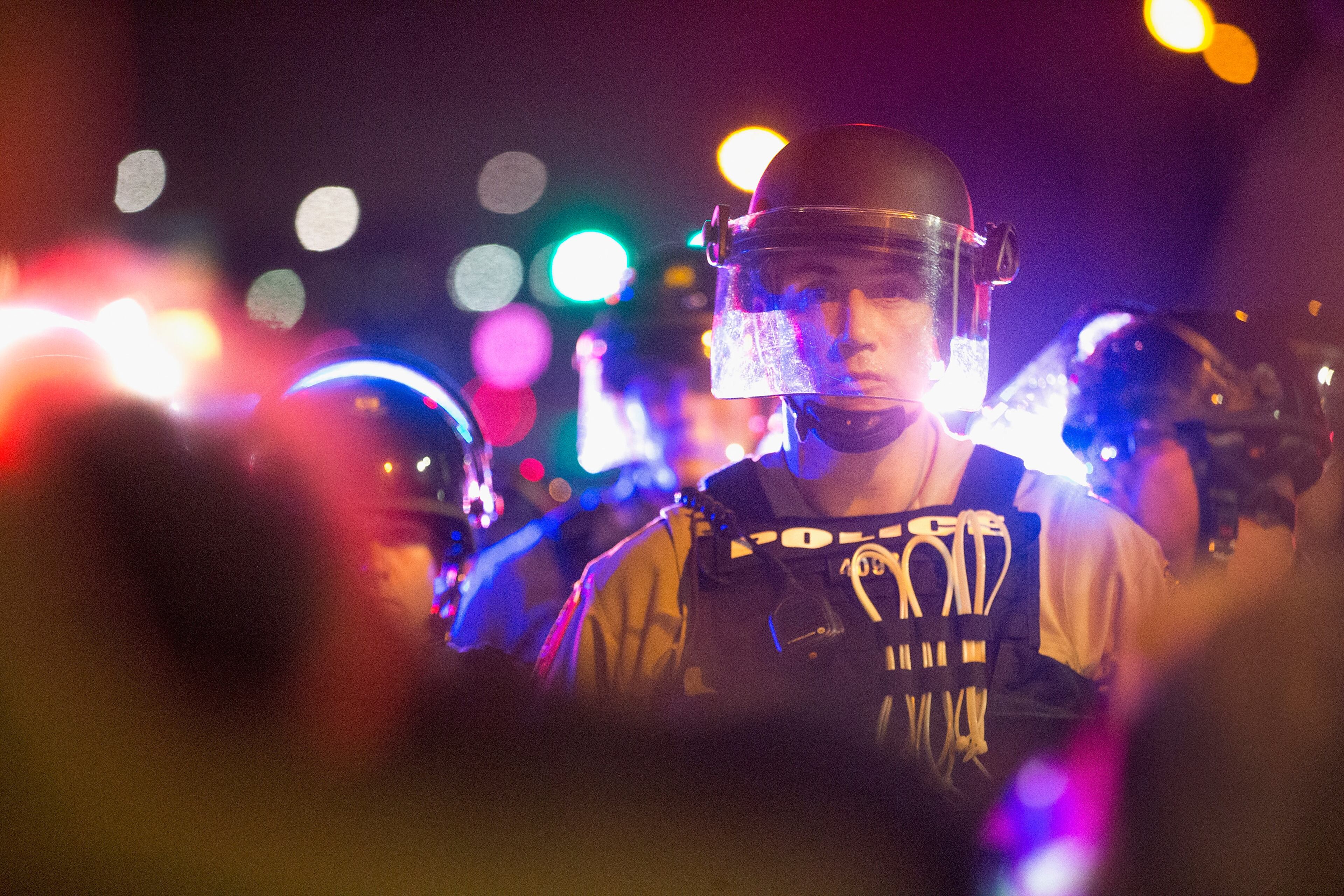 FERGUSON, MO - AUGUST 09: Demonstrators, marking the one-year anniversary of the shooting of Michael Brown, face off with police during a protest along West Florrisant Street on August 9, 2015 in Ferguson, Missouri. There are reports that two people were shot when gun fire broke out during protests later in the evening. Brown was shot and killed by a Ferguson police officer on August 9, 2014. His death sparked months of sometimes violent protests in Ferguson and drew nationwide focus on police treatment of black offenders. (Photo by Scott Olson/Getty Images)