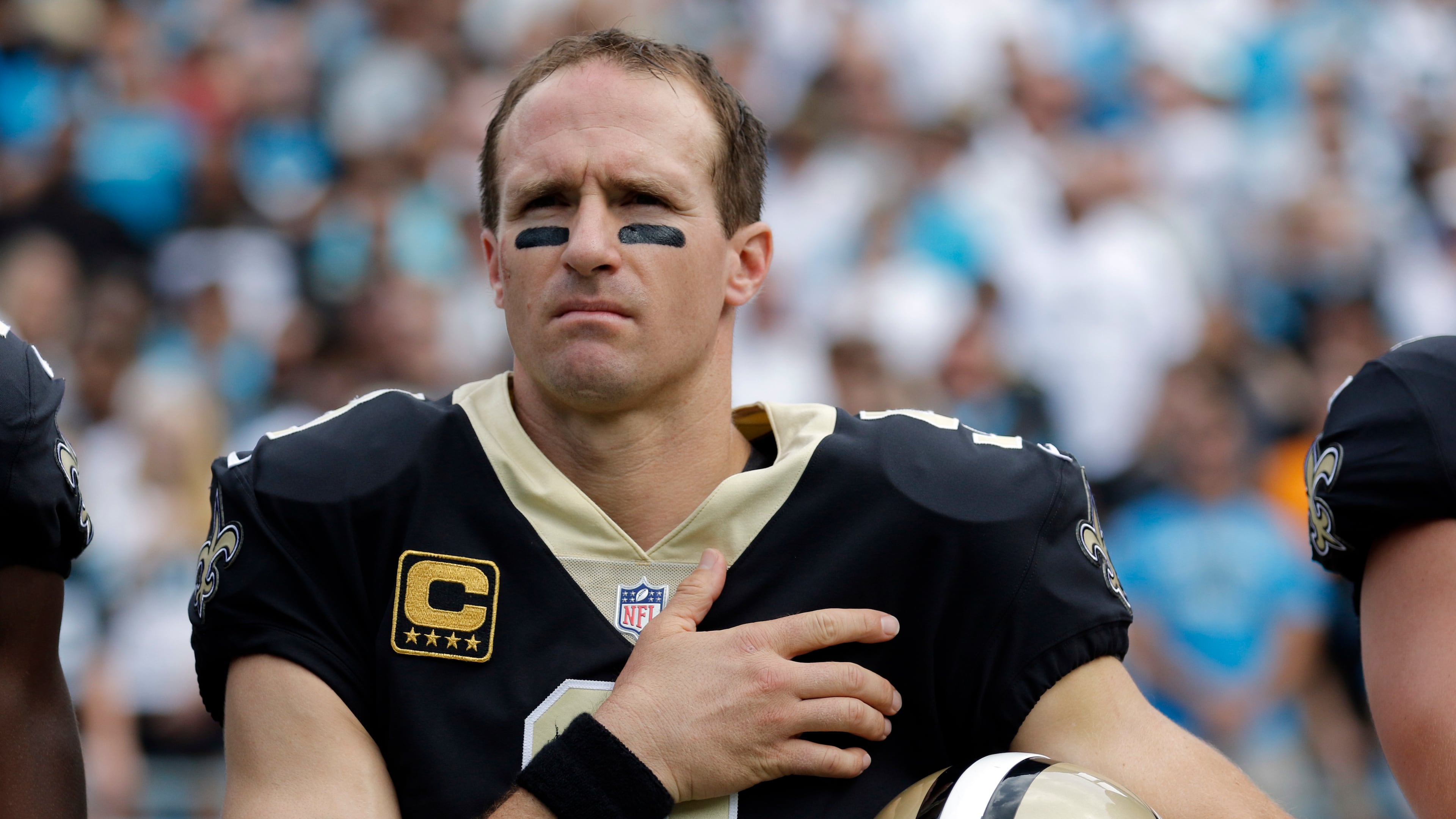 New Orleans Saints quarterback Drew Brees (9) stands with his hand over his heart during the national anthem before an NFL football game against the Carolina Panthers in Charlotte, N.C., Sunday, Sept. 24, 2017. Several Saints players sat on the bench during the anthem. (AP Photo/Bob Leverone)