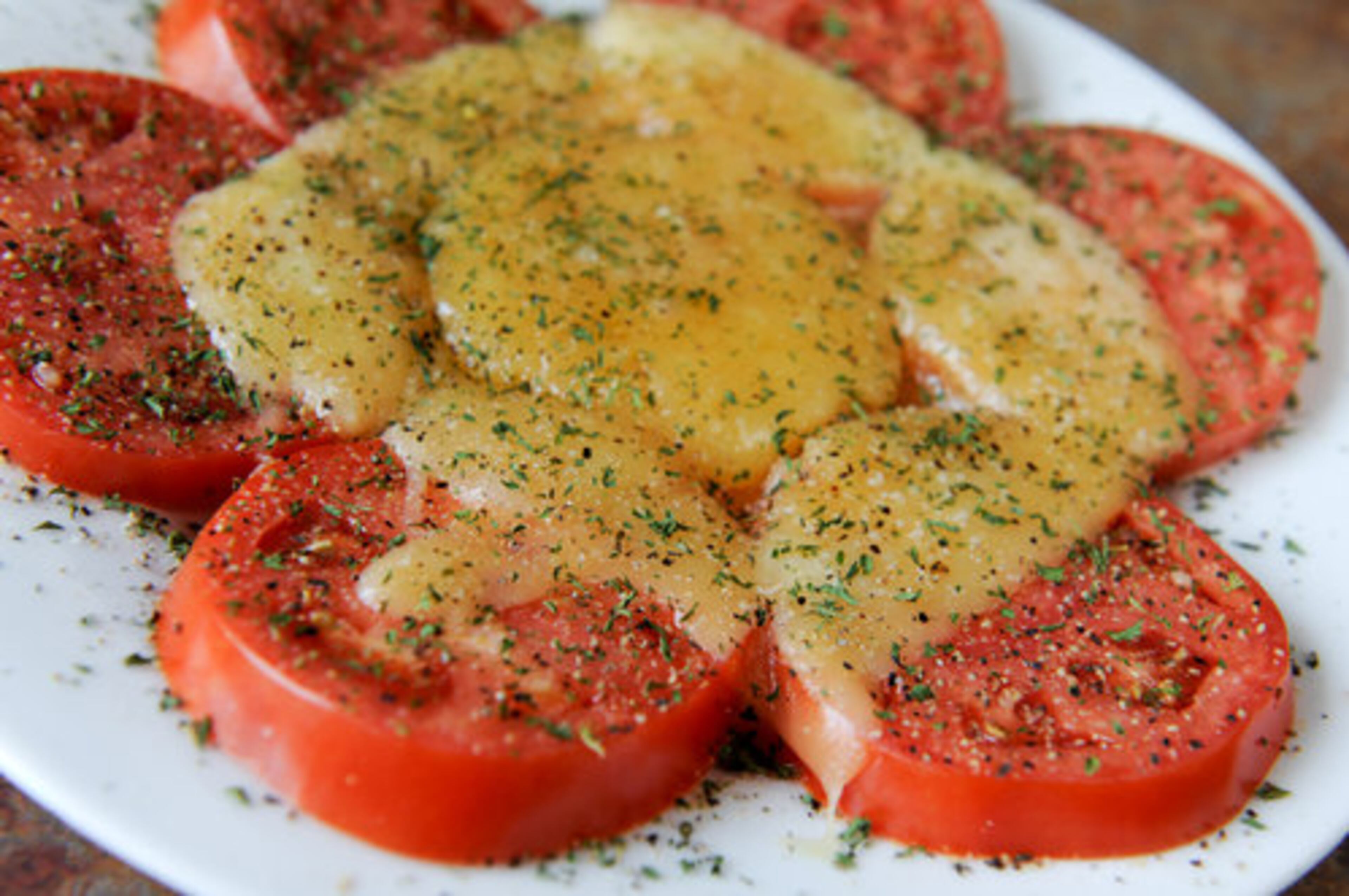 Tomato slices with melted havarti cheese at Nine Street Kitchen in Roswell, a place where "you may not find anything risky or refined, but sometimes simple pleasures are the most satisfying," writes Jenny Turknett. One star.