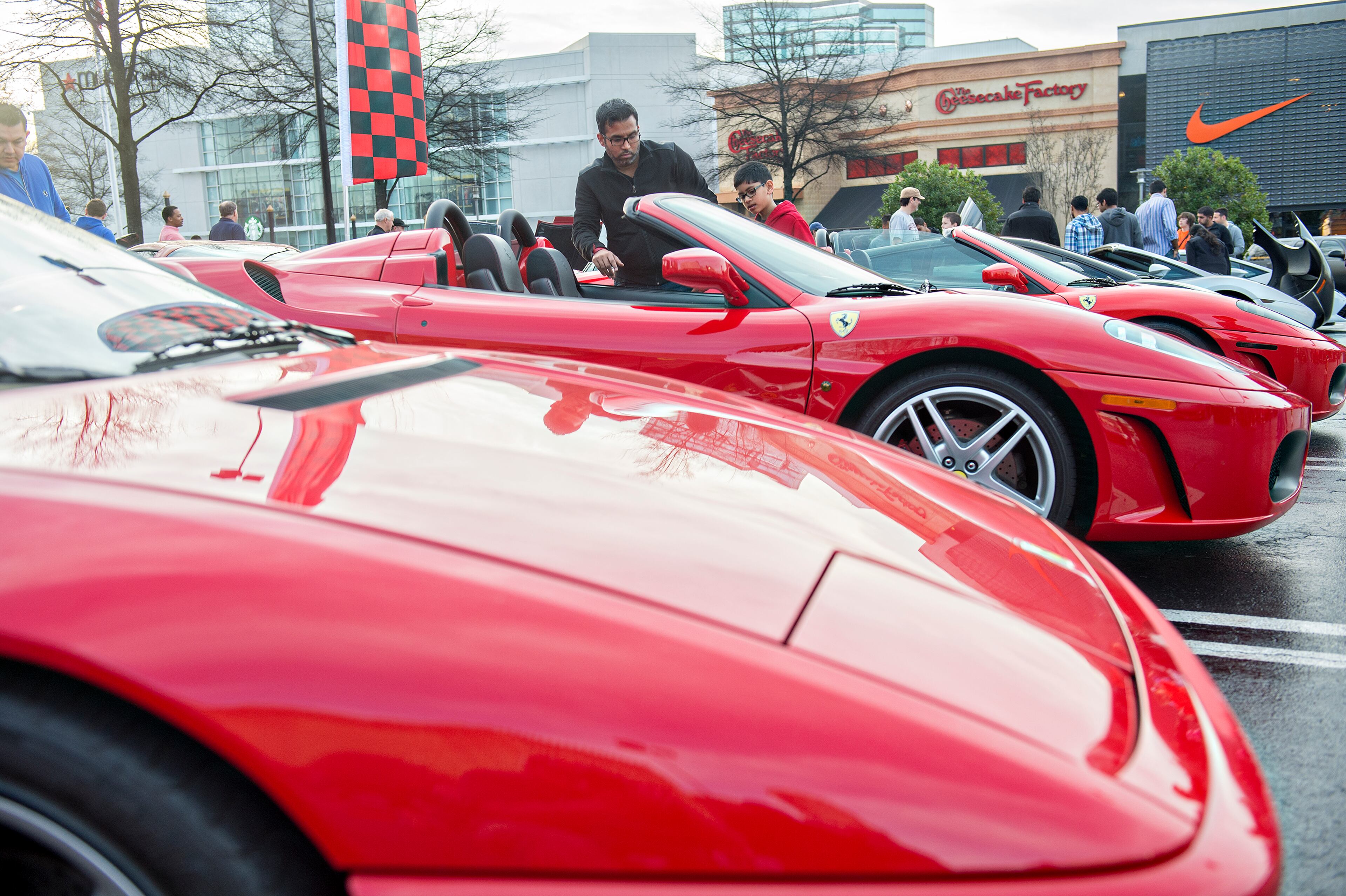 Raj Purohit (left) and his nephew Rishi Patel look in on Purohit's F430 Ferrari during the Caffeine & Exotics Car Show at Lenox Square Mall in Atlanta on Sunday, March 15, 2015. JONATHAN PHILLIPS / SPECIAL