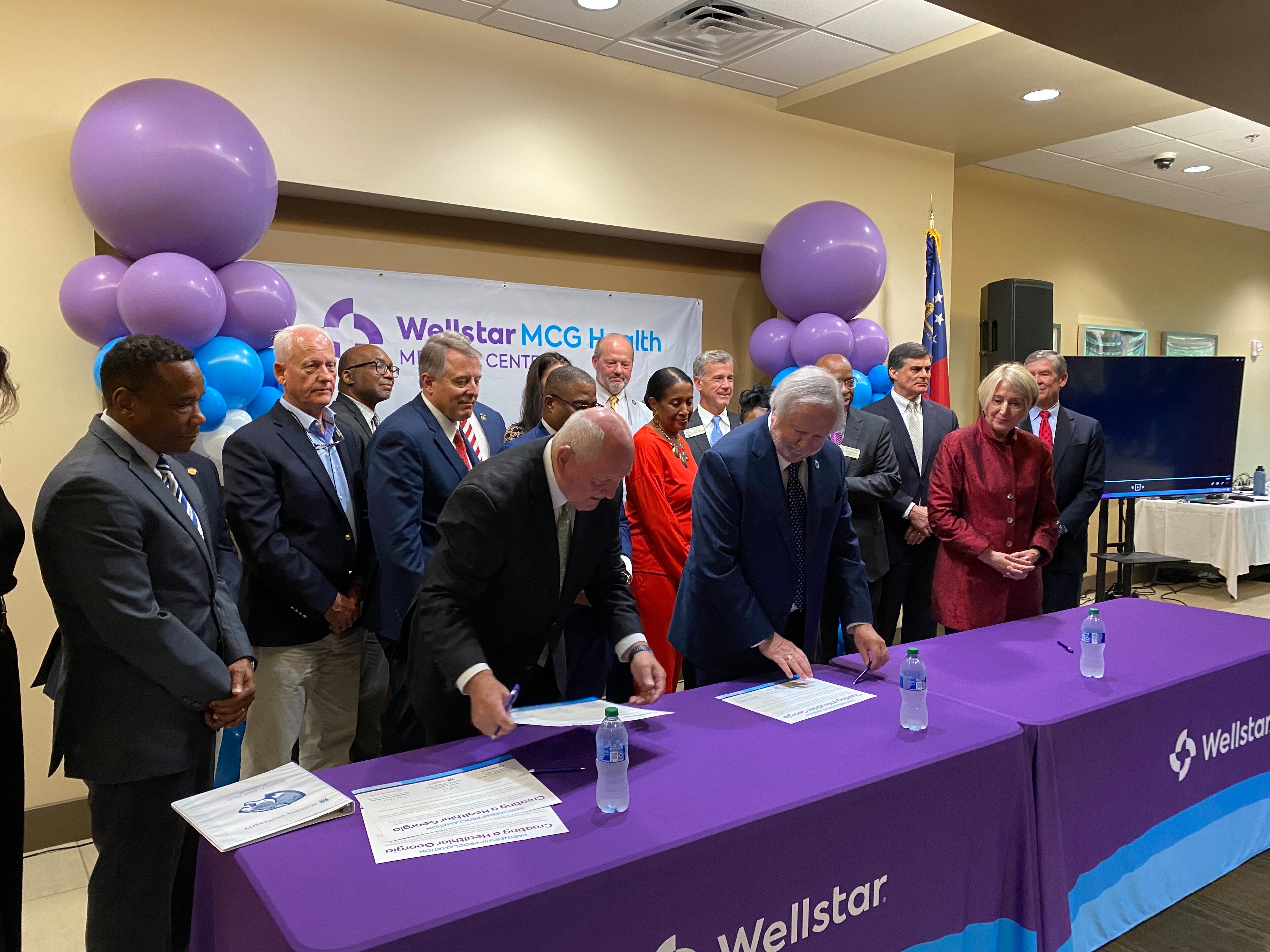 University System of Georgia Chancellor Sonny Perdue, left; Augusta University President Brooks Keel, center; and Wellstar Health System CEO Candice Saunders, right, sign the final papers for Wellstar's takeover of Augusta University Health at Augusta University Medical Center on August 30, 2023. AU Health will now be called Wellstar MCG Health. (PHOTO by Ariel Hart)