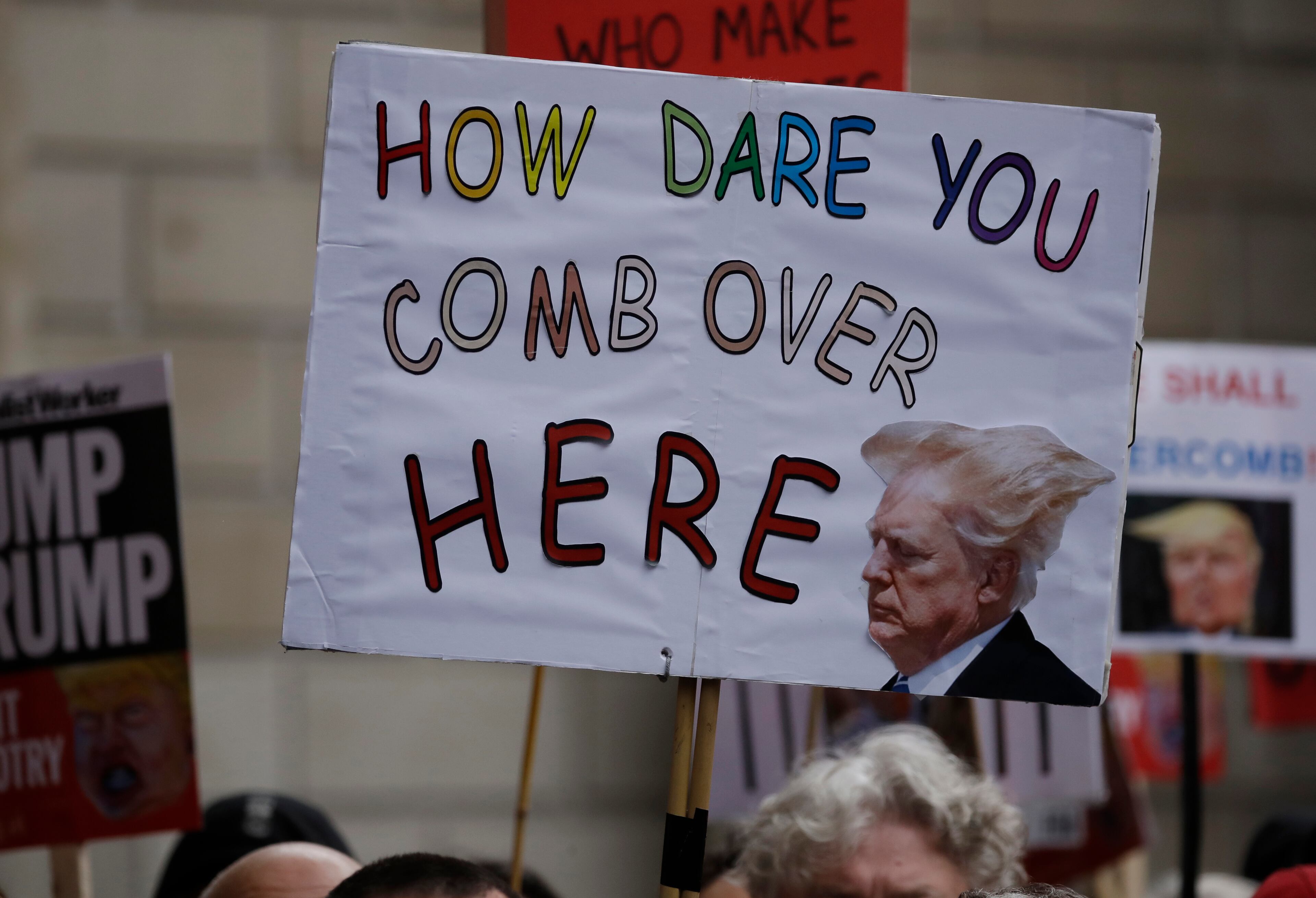 People carry banners as they gather in central London to demonstrate against the state visit of President Donald Trump, Tuesday, June 4, 2019. Trump will turn from pageantry to policy Tuesday as he joins British Prime Minister Theresa May for a day of talks likely to highlight fresh uncertainty in the allies' storied relationship. (AP Photo/Matt Dunham)