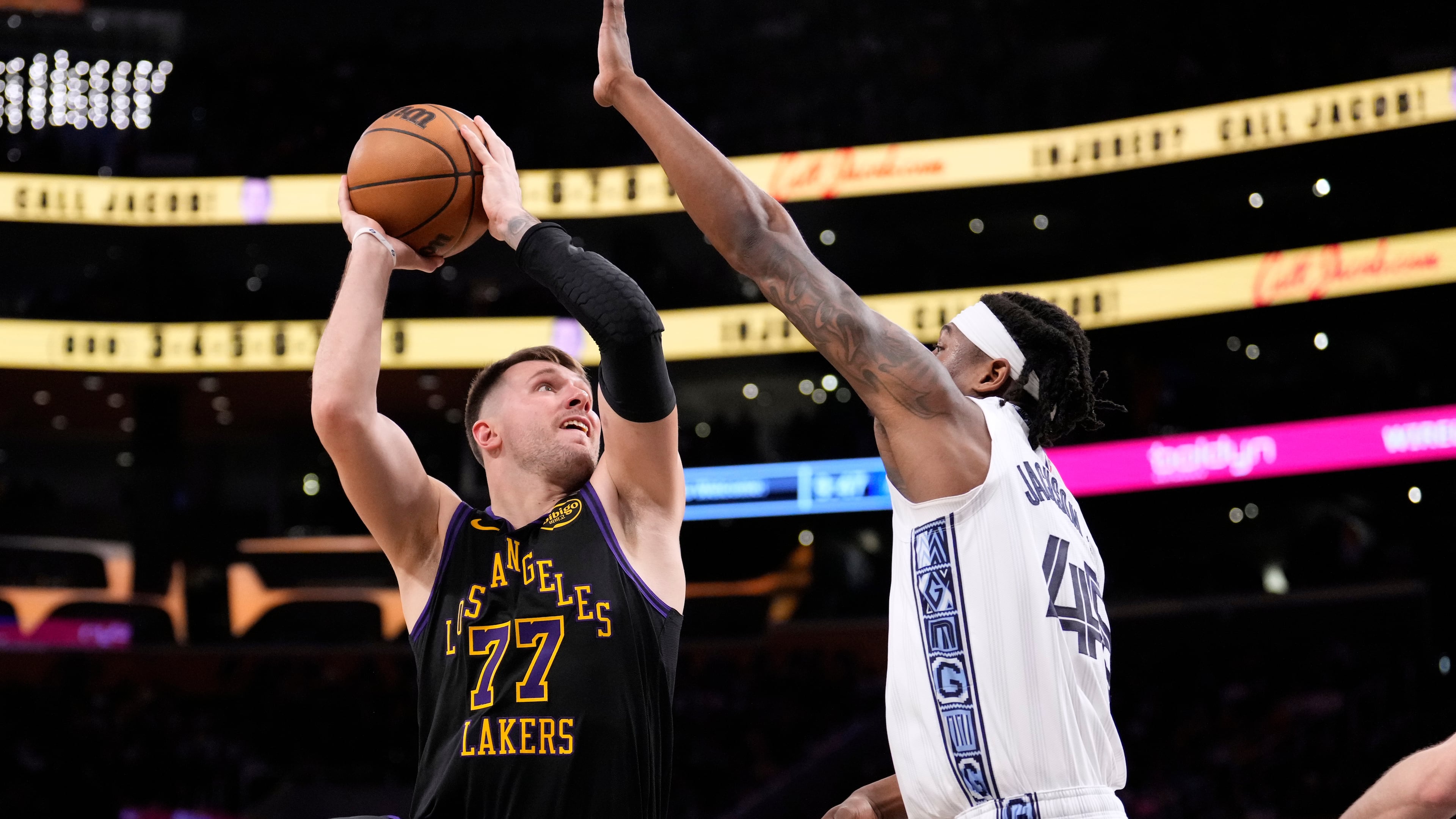 Los Angeles Lakers guard Luka Doncic, left, shoots as Memphis Grizzlies forward GG Jackson defends during the second half of an NBA basketball game Friday, Jan. 2, 2026, in Los Angeles. (AP Photo/Mark J. Terrill)