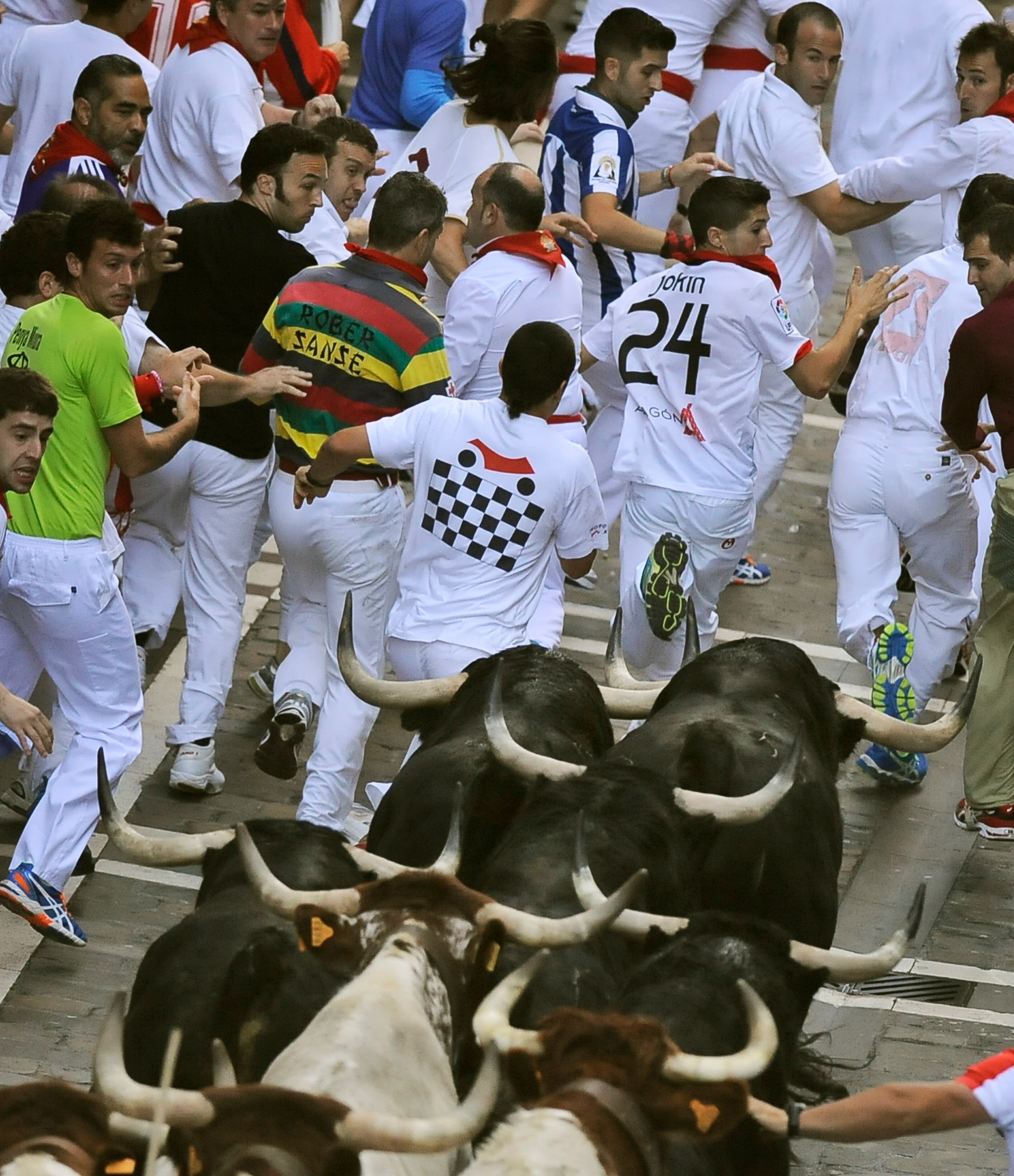 Revelers run with Valdefresno ranch fighting bulls on Estafeta street during the San Fermin fiestas, Tuesday, July 9, 2013, in Pamplona, Spain. Revelers from around the world come to participate in the street partying festival, which became world famous with the 1926 publication of Ernest Hemingway's novel "The Sun Also Rises." (AP Photo/Alvaro Barrientos)