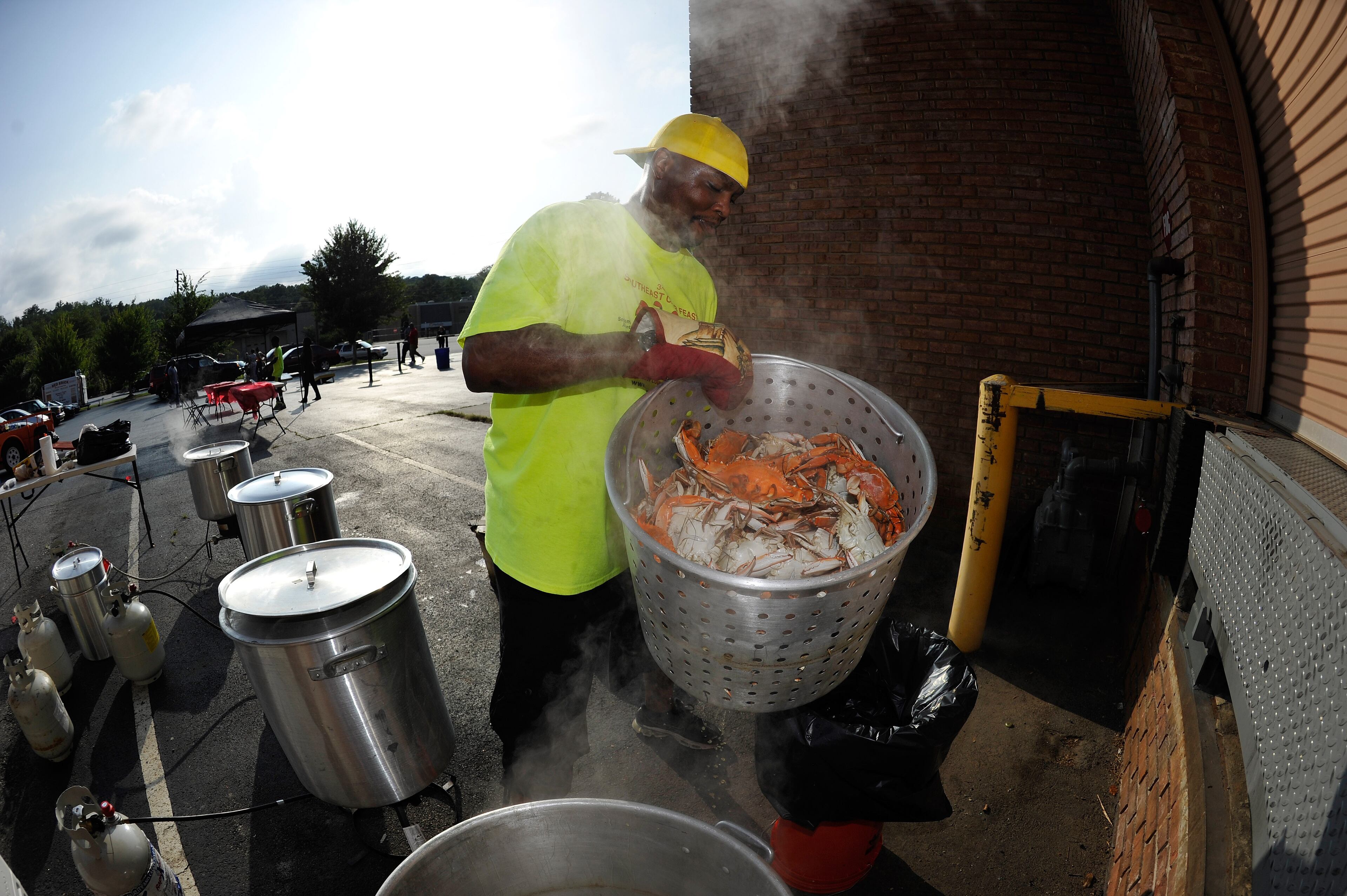 Cook Jamell Hamilton pulls an 80-quart pot from boiling water steaming some of the 35 bushels of crabs during the Atlanta Crabs & Beer Fest at the Red Brick Brewery on Saturday, July 19, 2014, in Atlanta. David Tulis / AJC Special