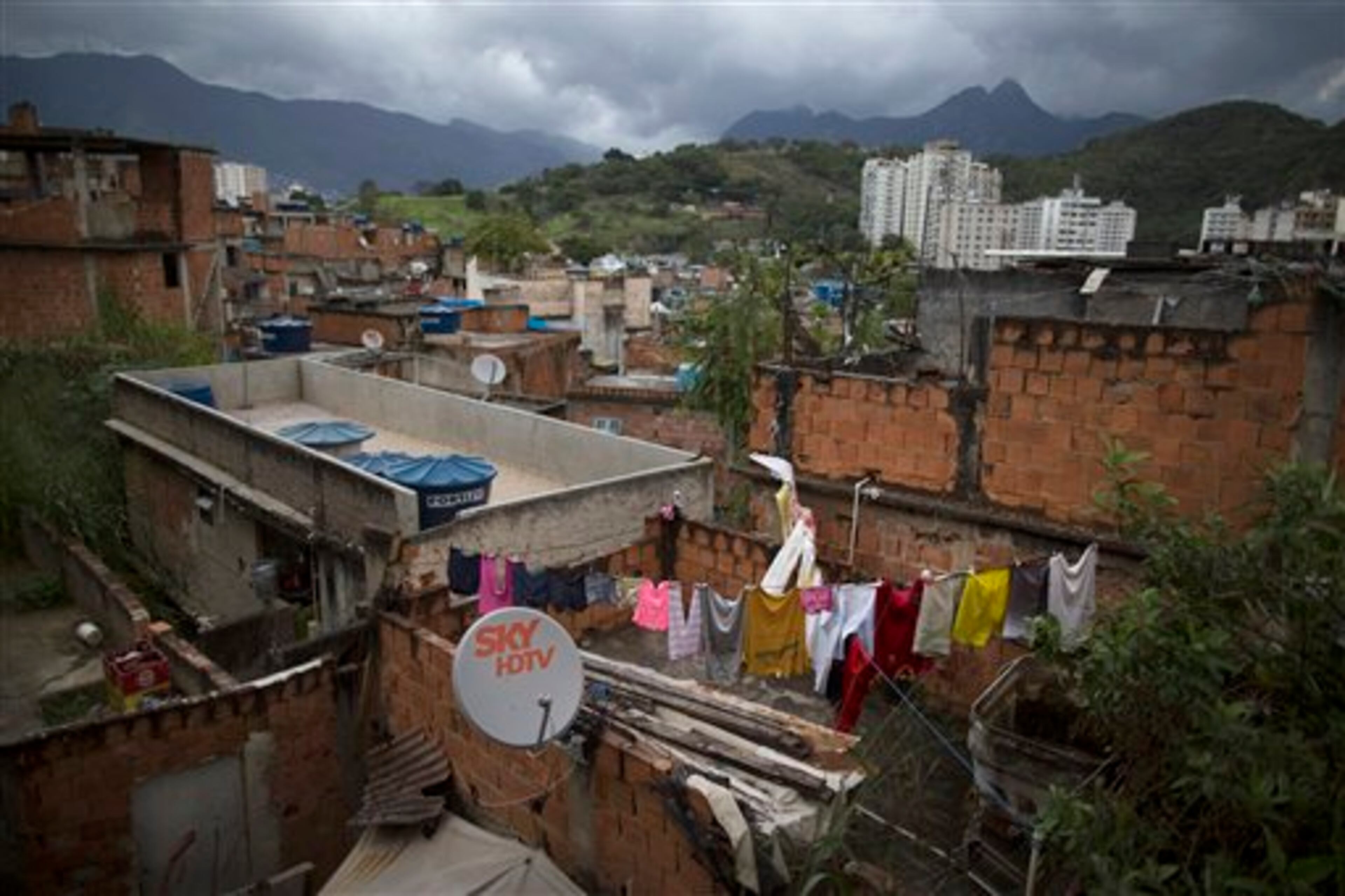 In this Monday, June 2, 2014 photo, clothes hang to dry on the roof of a home in the Mangueira slum of Rio de Janeiro, Brazil. Less than half a kilometer separates the sprawling slum from the fabled Maracana stadium, where seven World Cup matches will be played, including the July 13 final. (AP Photo/Leo Correa)